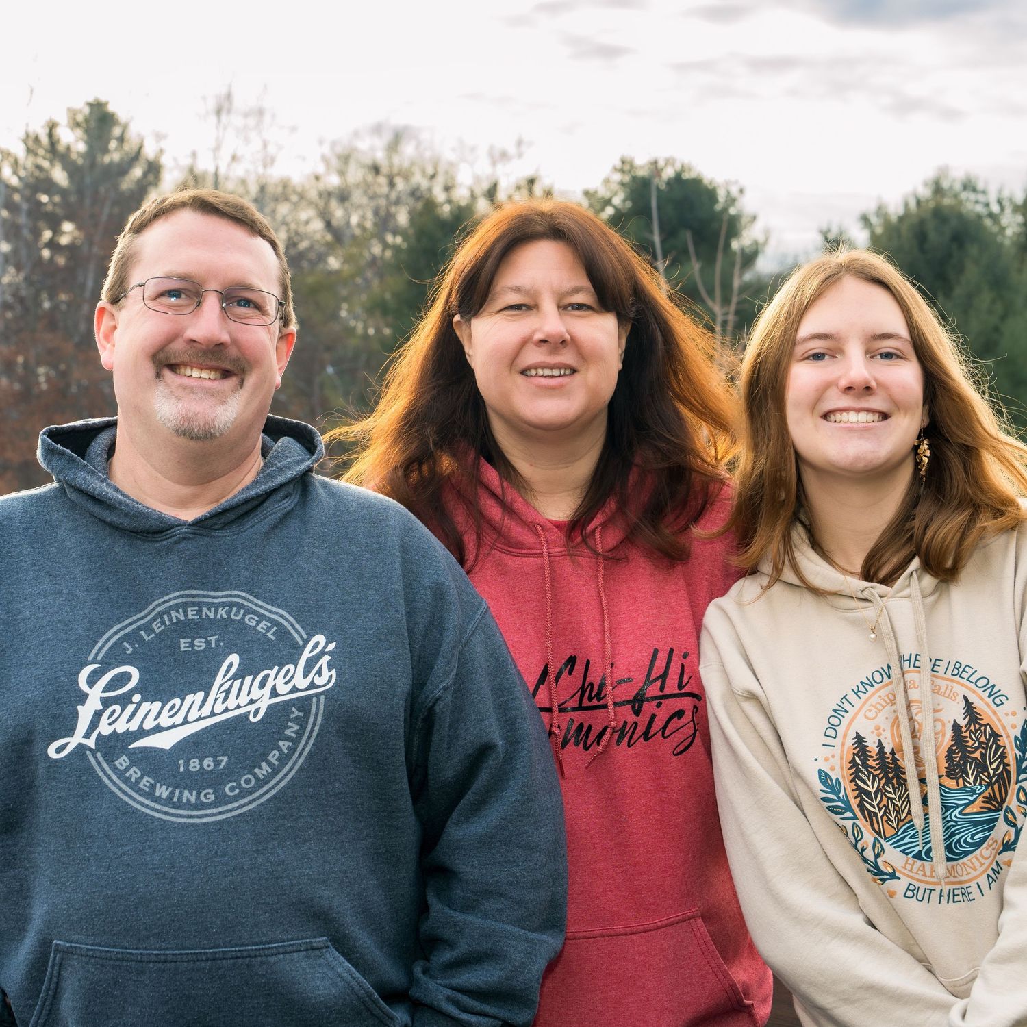 Family portrait session outdoors with matching casual outfits.