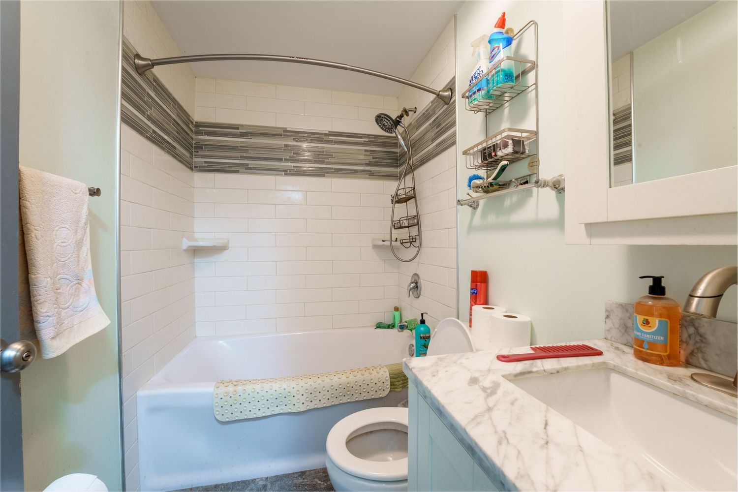 A modern bathroom interior with white marble tiles, glass shower enclosure, and sleek fixtures shown from multiple angles.