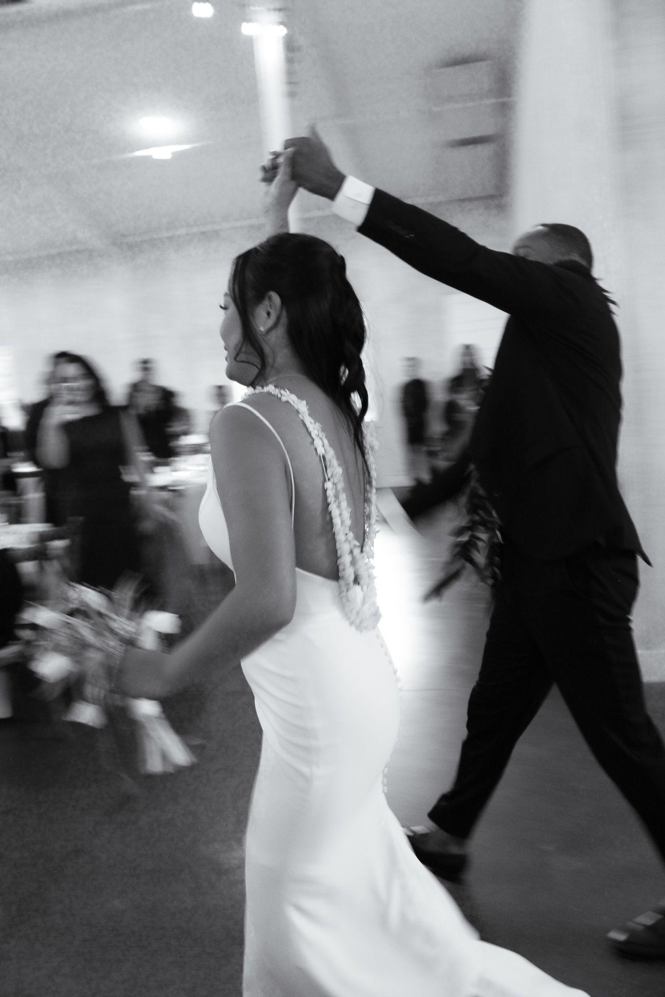 The bride and groom are entering the reception dancing.