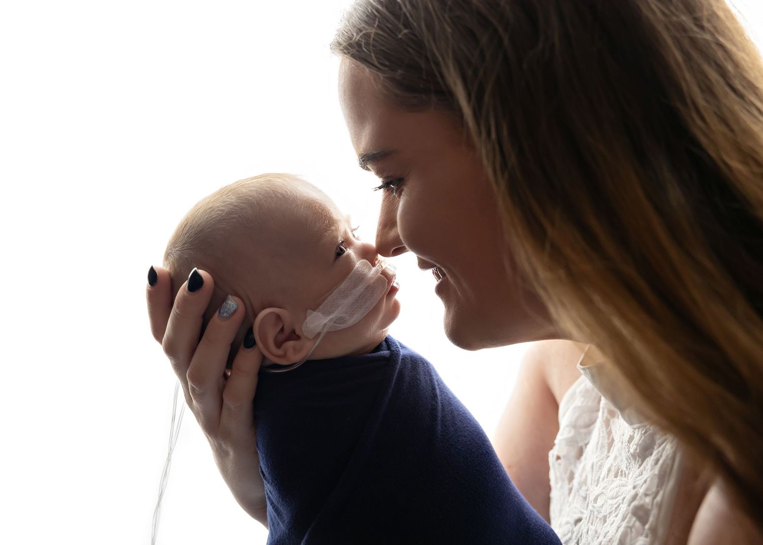 A couple shares a tender kiss in silhouette against a bright backlit background.Toowoomba Photographer