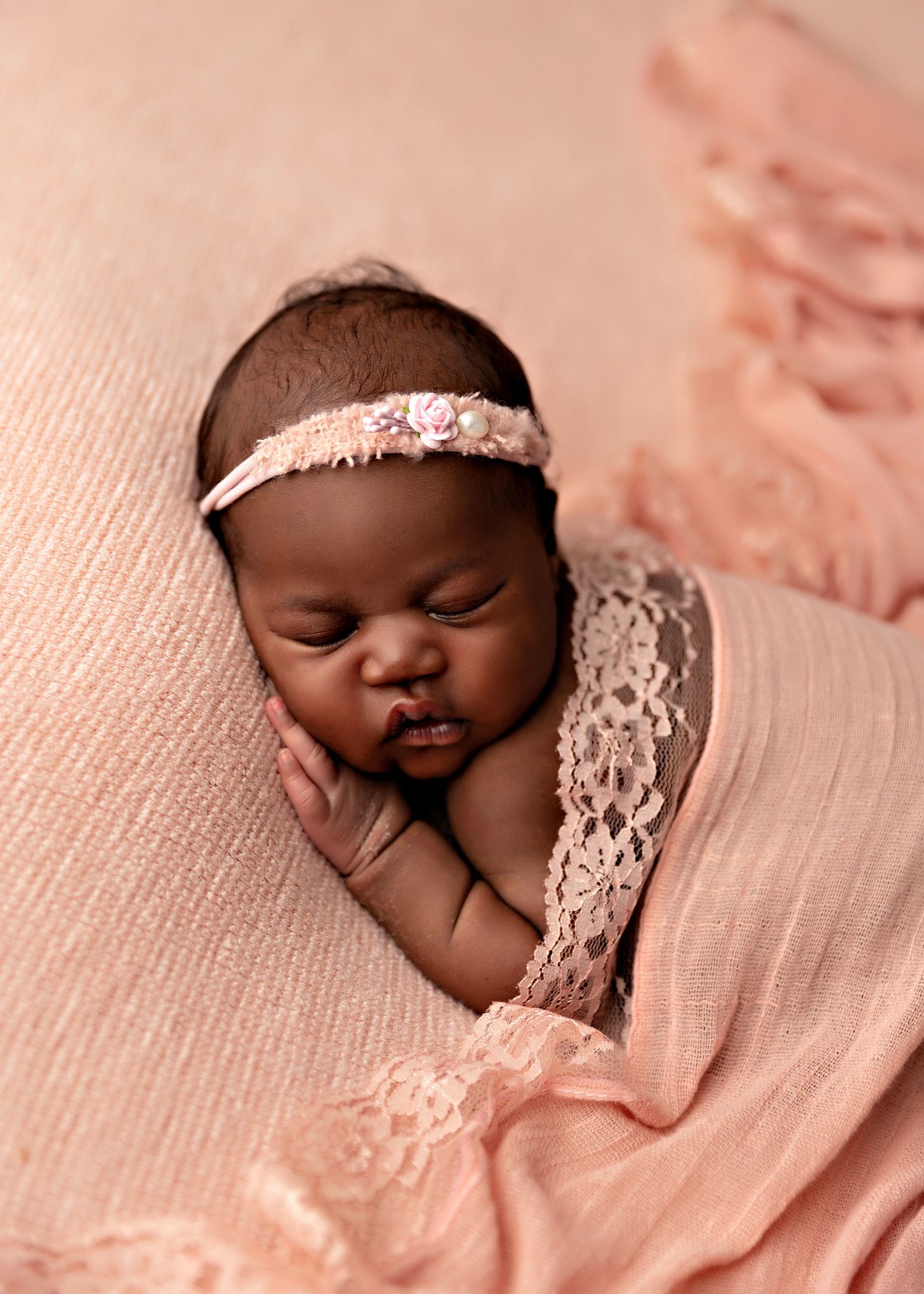 Newborn baby sleeping on pink fabric with delicate lace accessoriesToowoomba Photographer Toowoomba Newborn Photographer