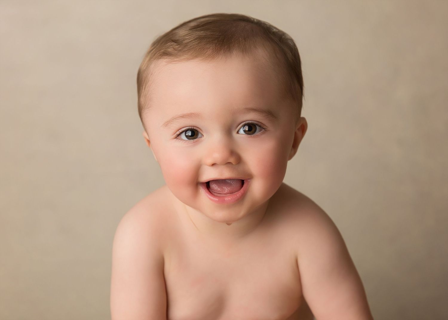 A series of baby portraits showing joyful expressions against a neutral beige background.Toowoomba Photographer Toowoomba Newborn Photograph