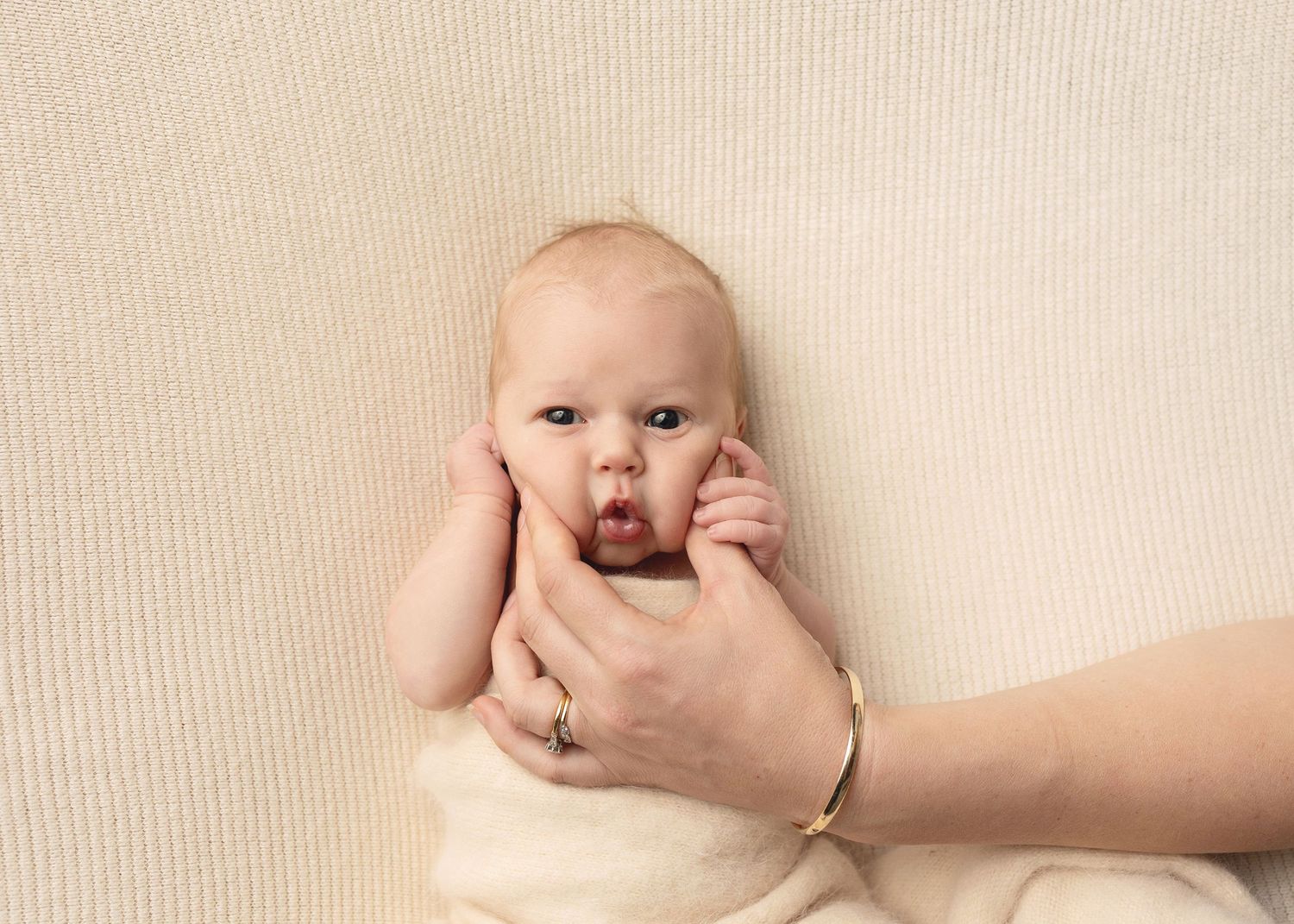 Series of artistic newborn photography poses on cream colored background showing delicate details.