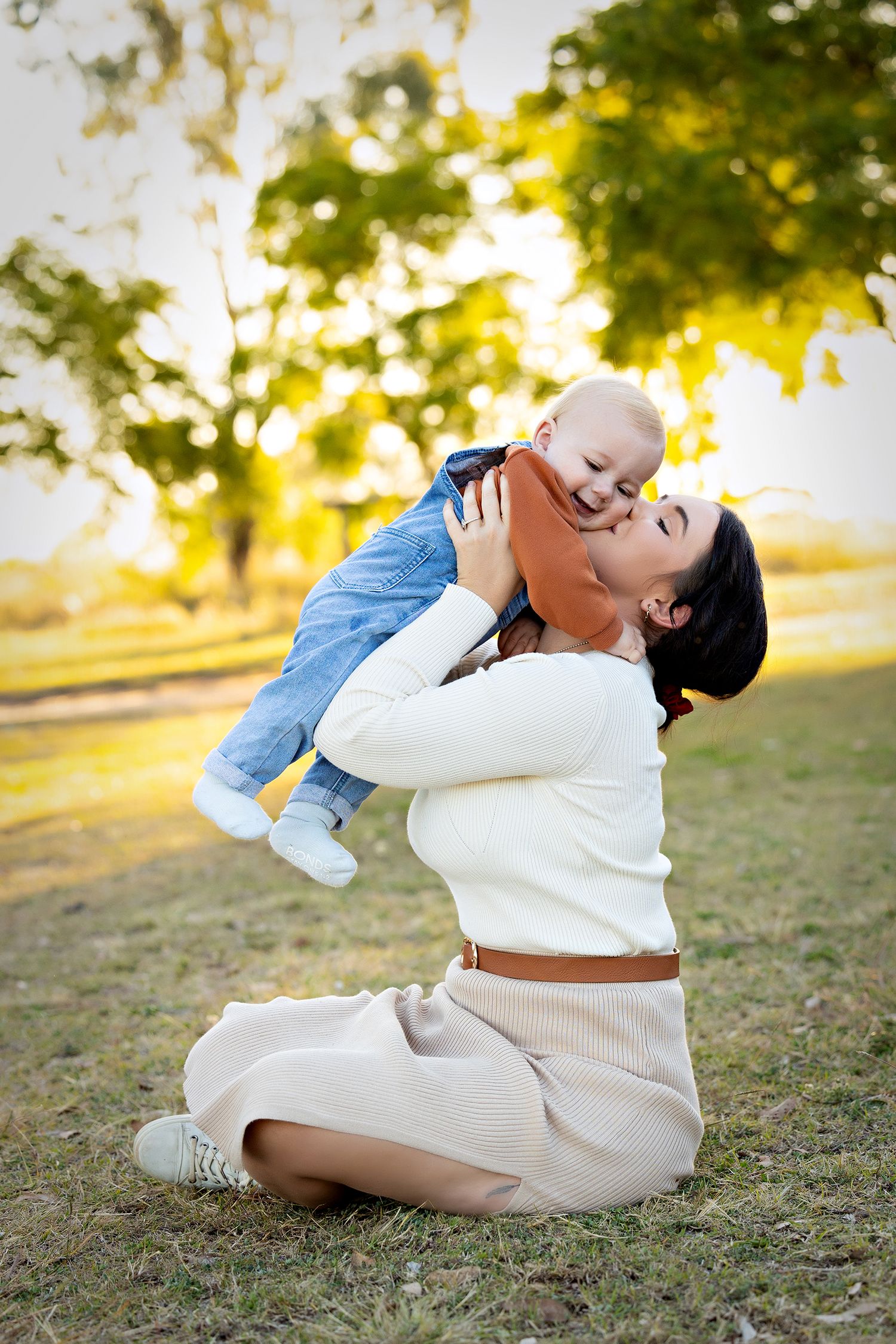 Sweet candid moments between family members on grass during golden hour.Toowoomba Photographer Toowoomba Newborn Photographer