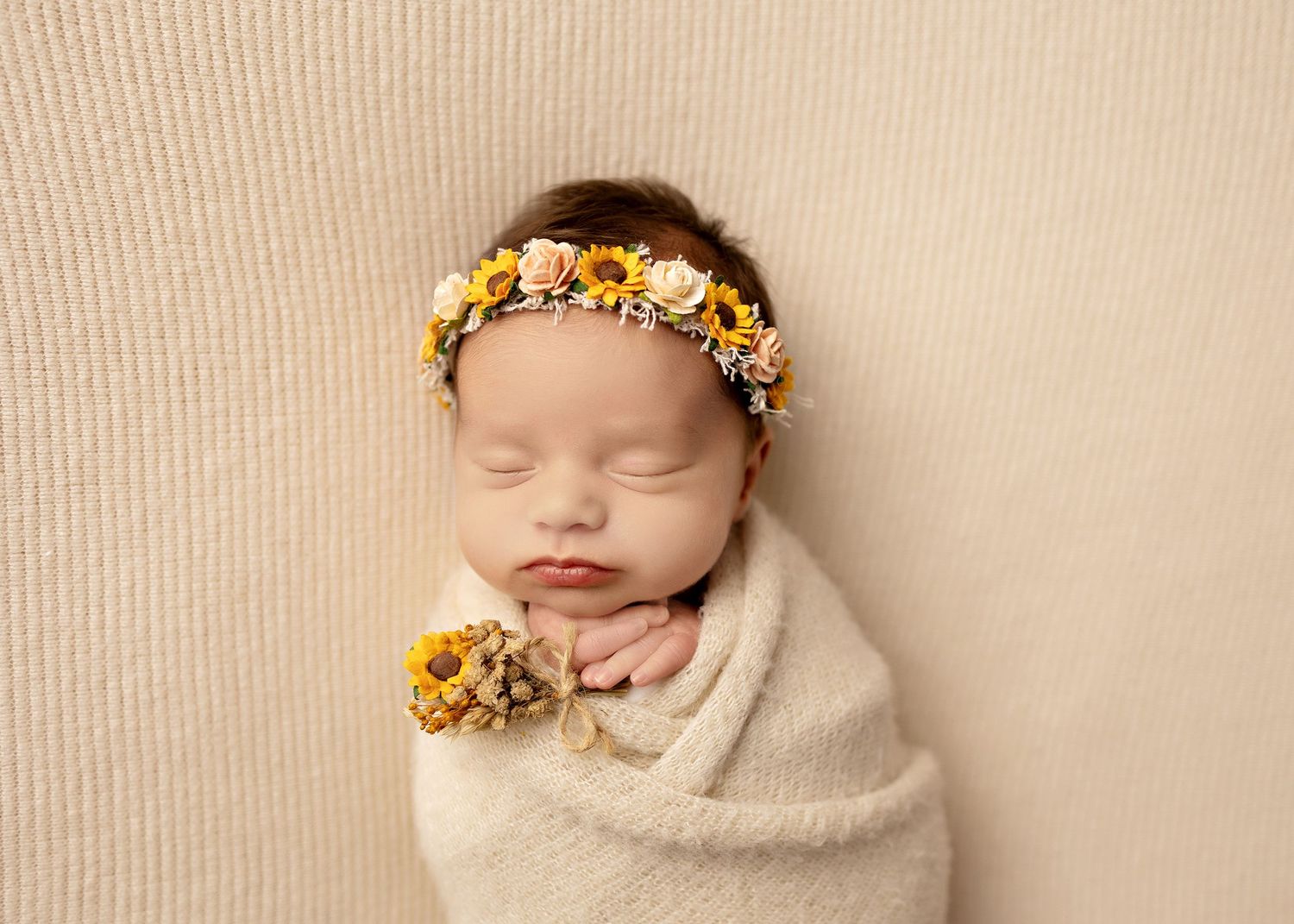 Sleeping newborn wrapped in white swaddle with yellow flower crownToowoomba Photographer Toowoomba Newborn Photographer