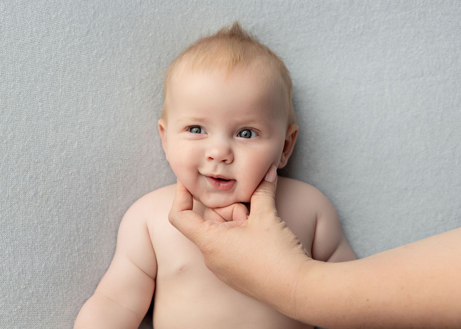 Series of infant portraits showing different expressions against a light gray wall.Toowoomba Photographer Toowoomba Newborn Photographer