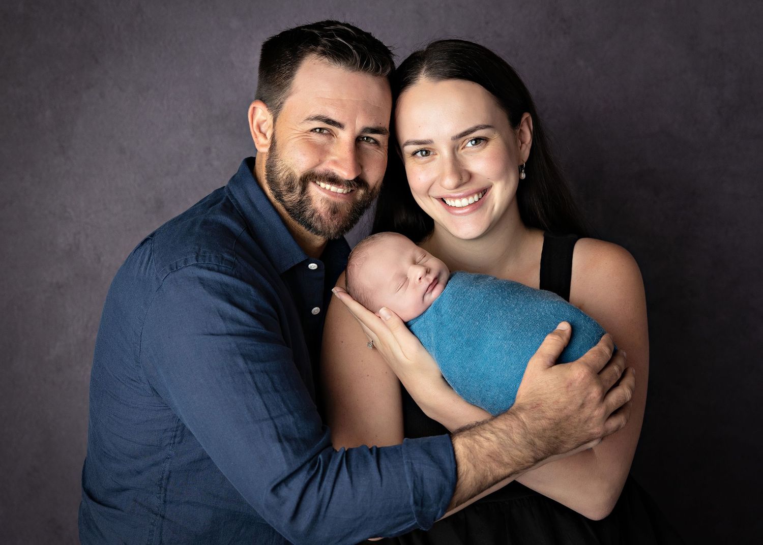 A series of six intimate portrait photos showing a couple embracing and smiling against a dark gray backdrop.