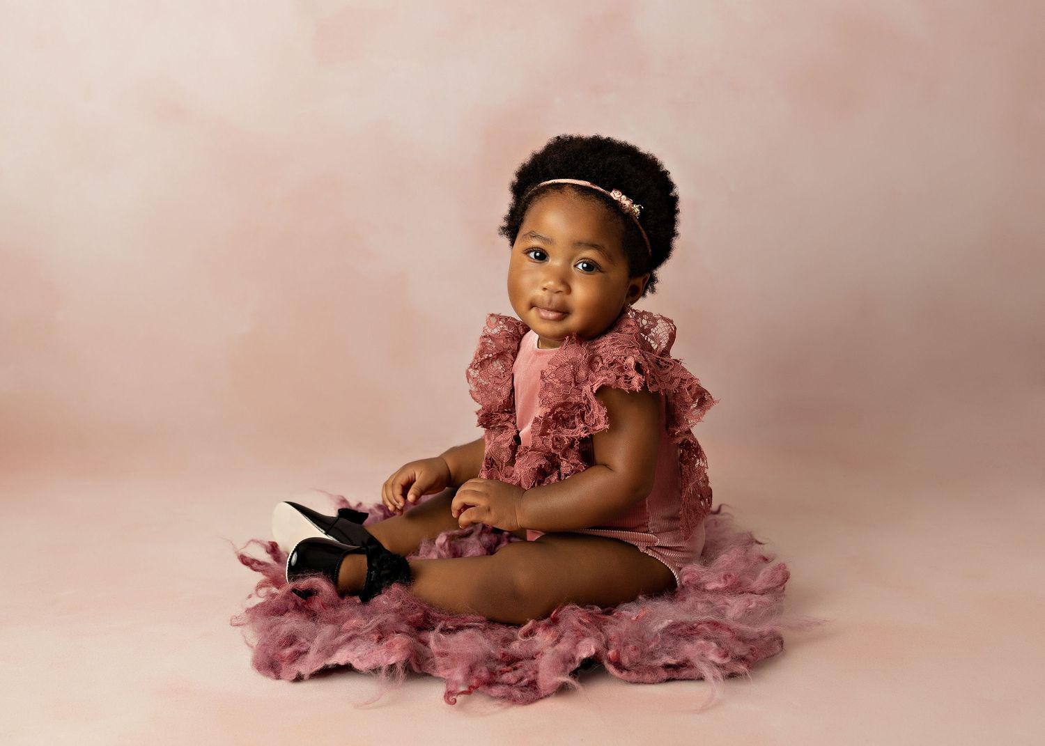 Baby wearing pink tulle dress posing on pink background with vintage styling.