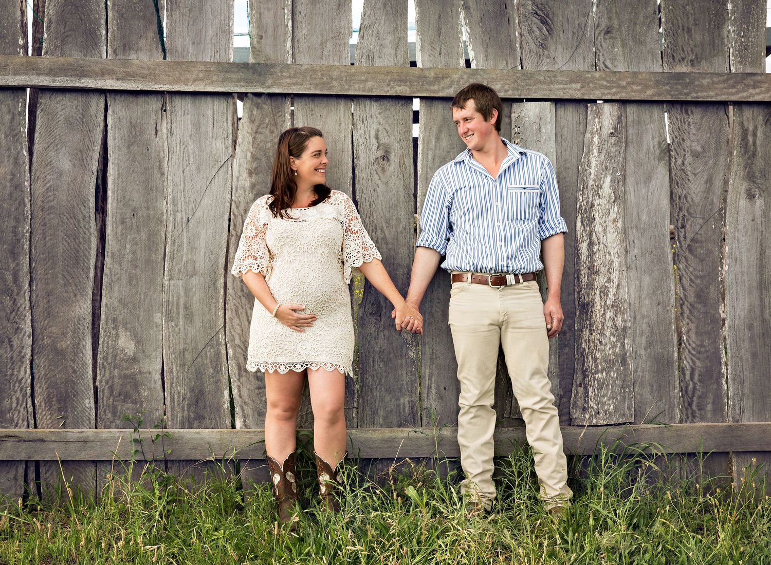 Rustic wooden fence provides backdrop for casual outdoor portraits.