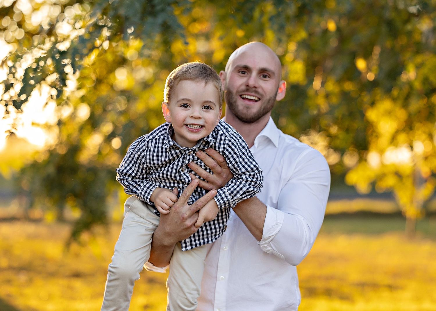 Playful family moments captured during sunset with warm golden lighting and trees.Toowoomba Photographer Toowoomba Newborn Photographer