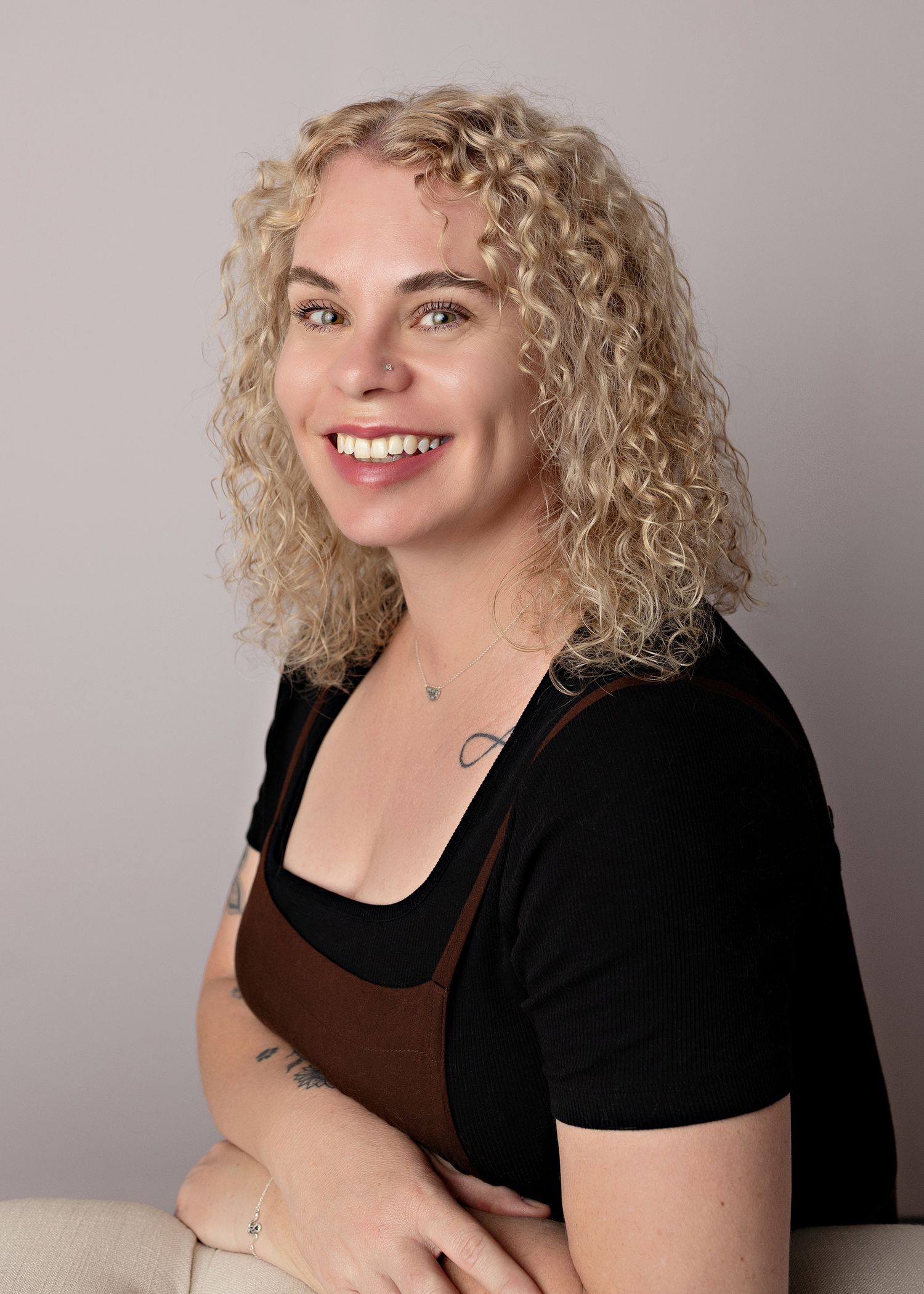 Professional headshots of woman in black jacket against grey background showing different expressions. Toowoomba Photographer