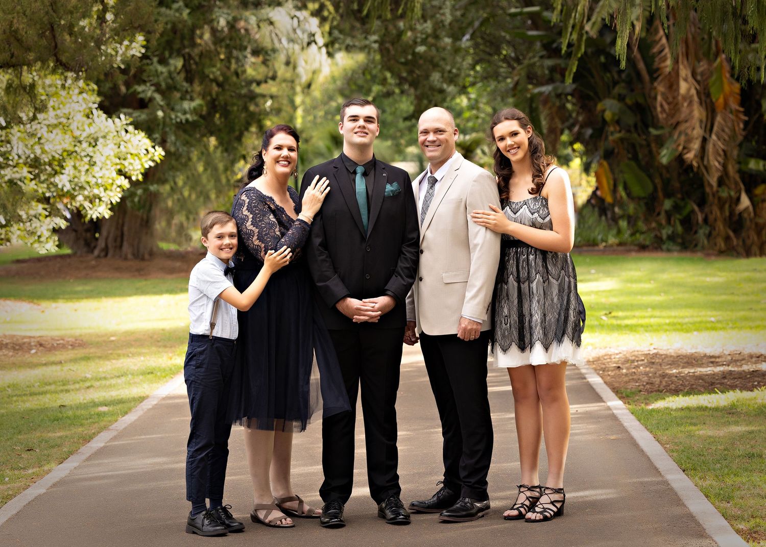 Wedding party group photo session on a paved pathway in a park setting.Toowoomba Photographer Toowoomba Newborn Photographer