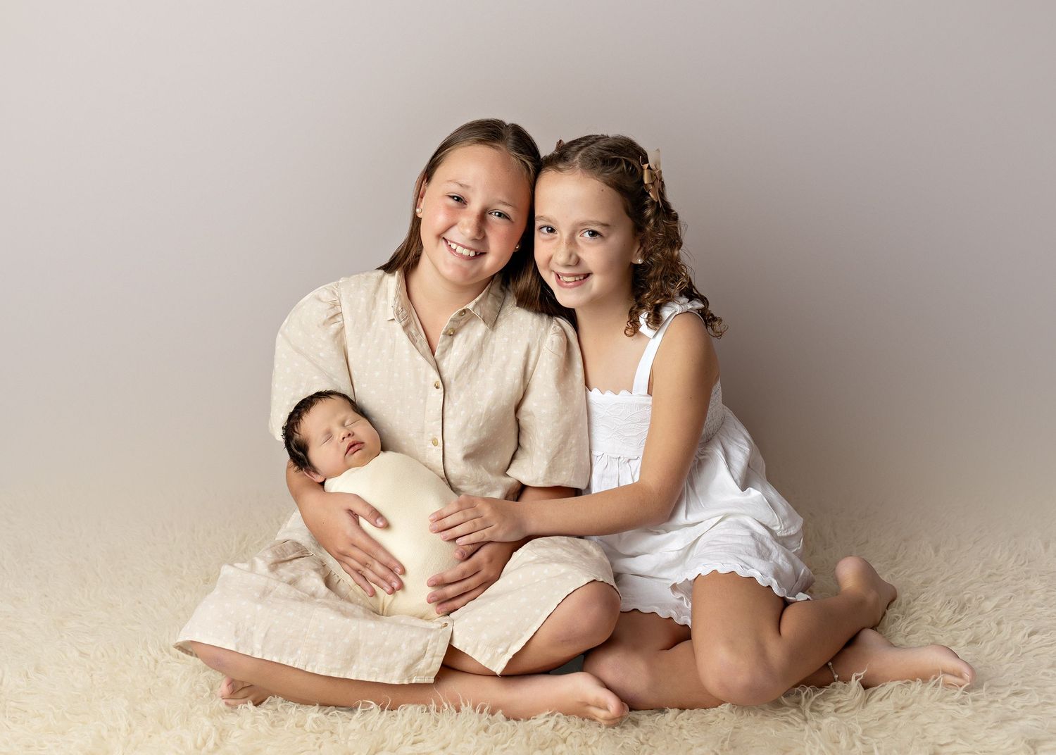 A collection of warm-toned family portrait photographs showing loving moments with a newborn on a neutral background.