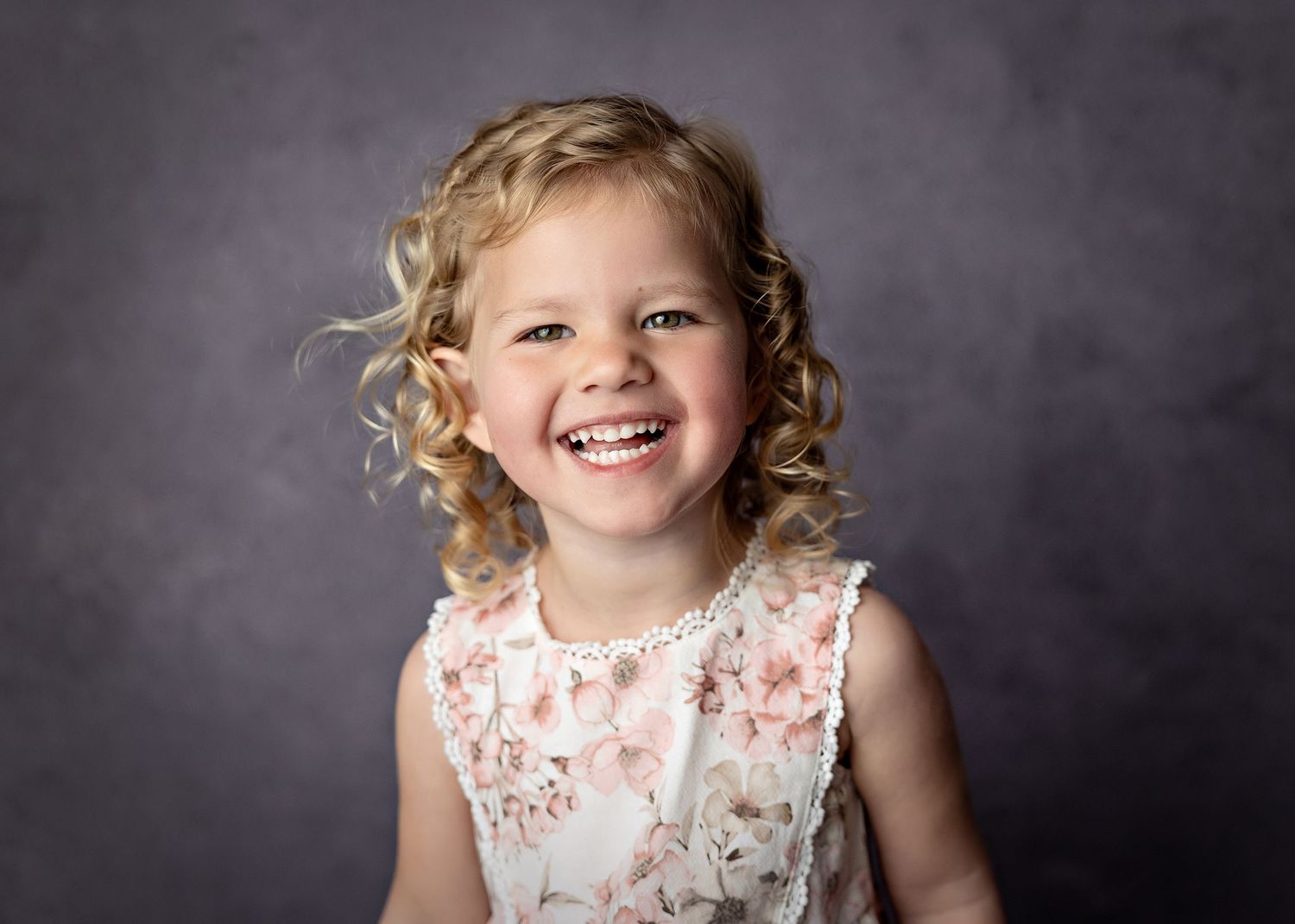 Series of portrait shots showing a young child in a floral dress against a dark background.Toowoomba Photographer Toowoomba Newborn Photogra