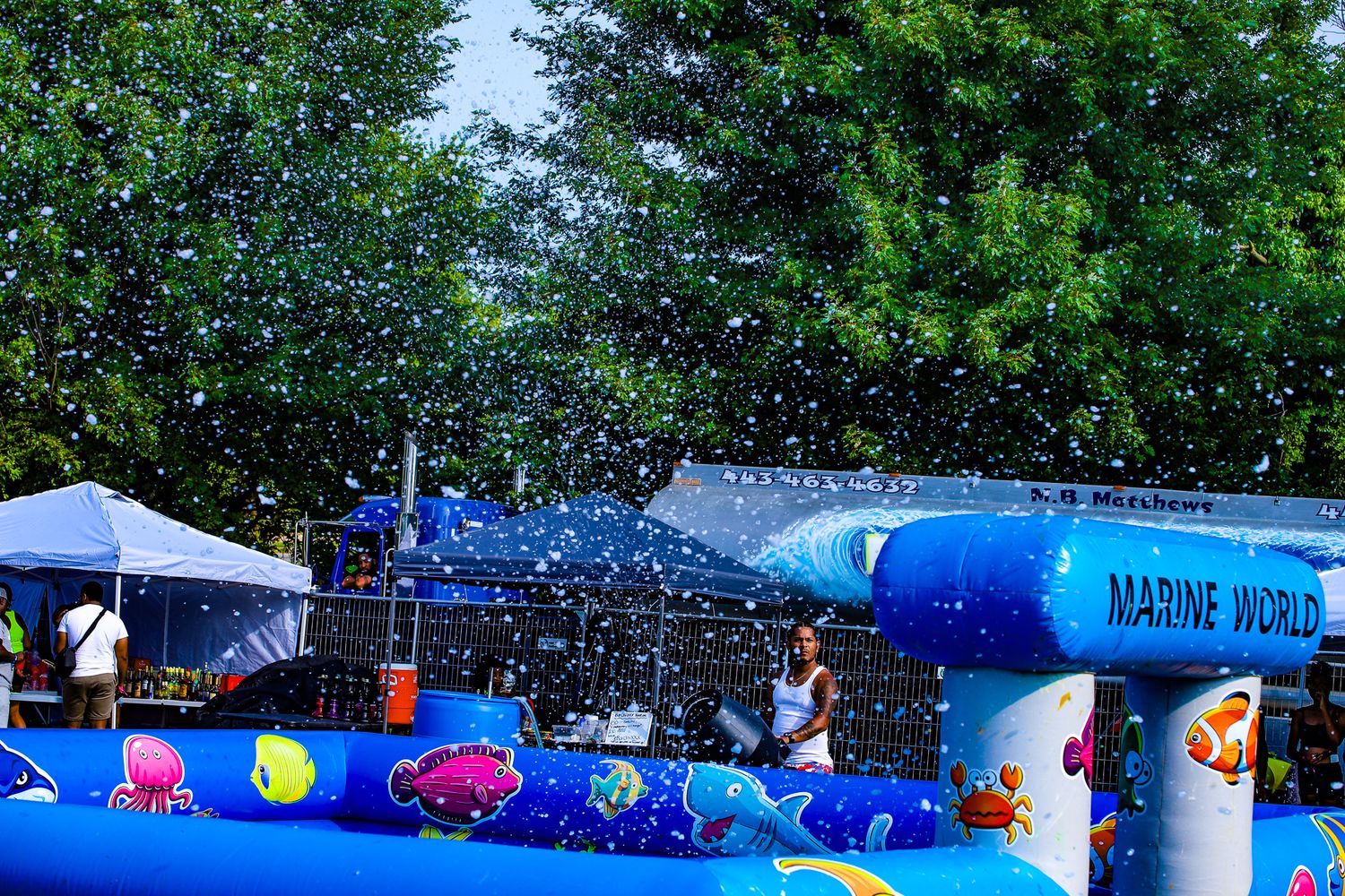 Colorful Marine World inflatable water play area with sprinklers at outdoor summer festival event.