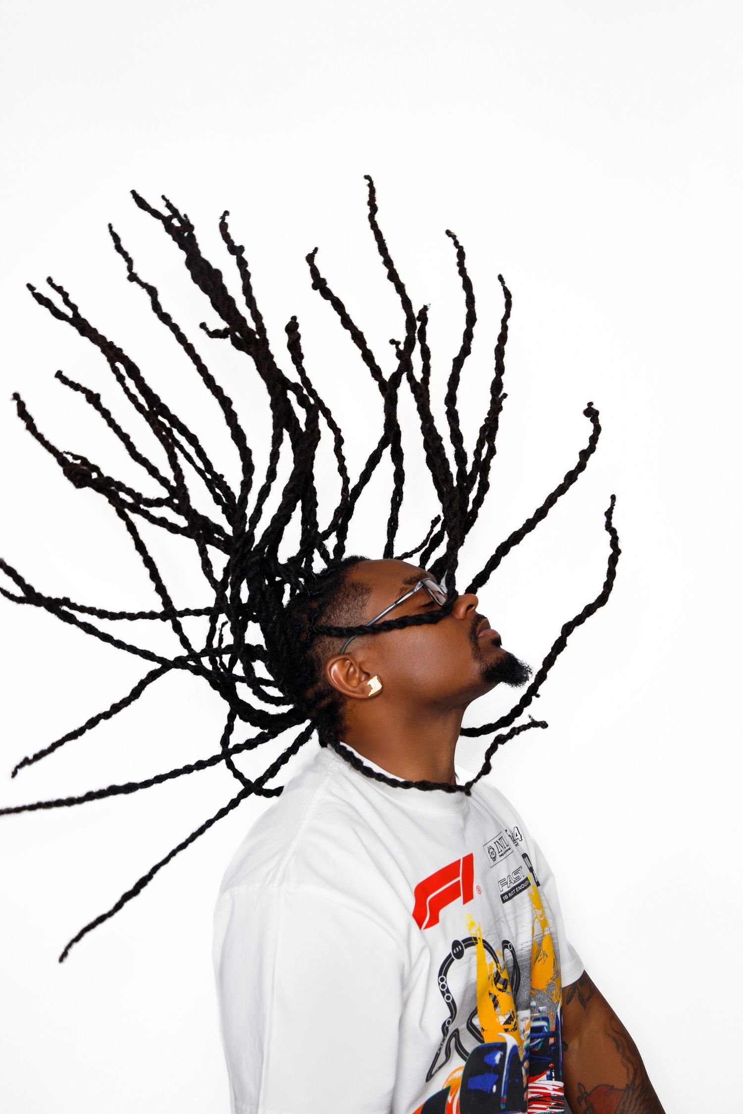 Dynamic motion shot of dreadlocks swinging through the air against white background,