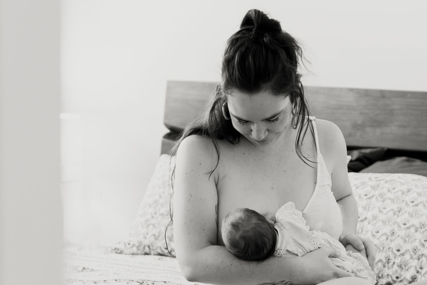 mother breastfeeding newborn in black and white photo
