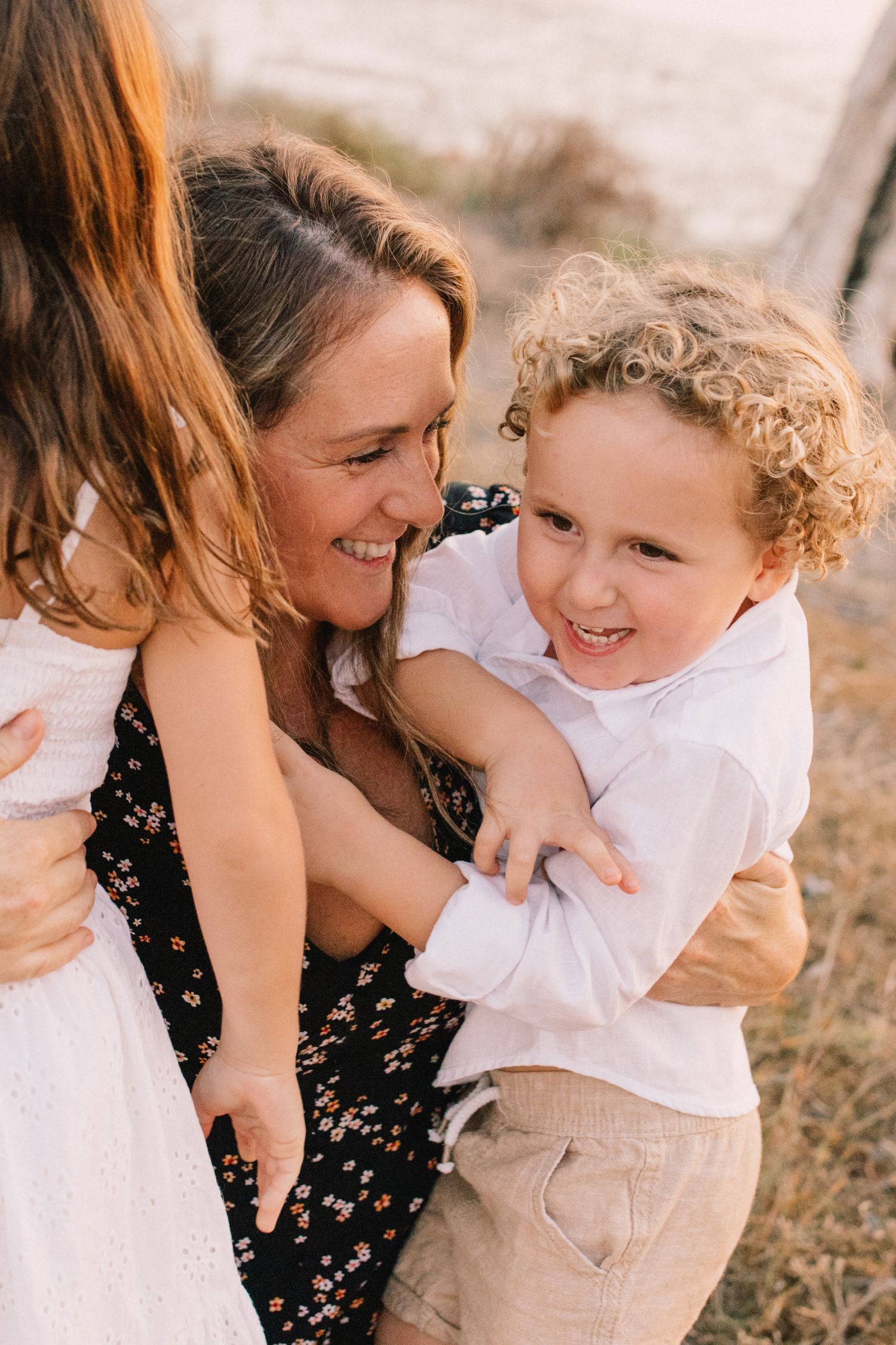 mother and son and daughter hugging and laughing