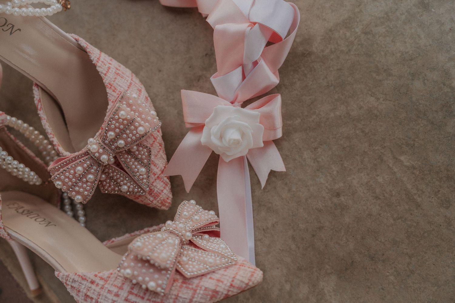 Close-up detail of pink ribbons and delicate lace trim on fabric.
