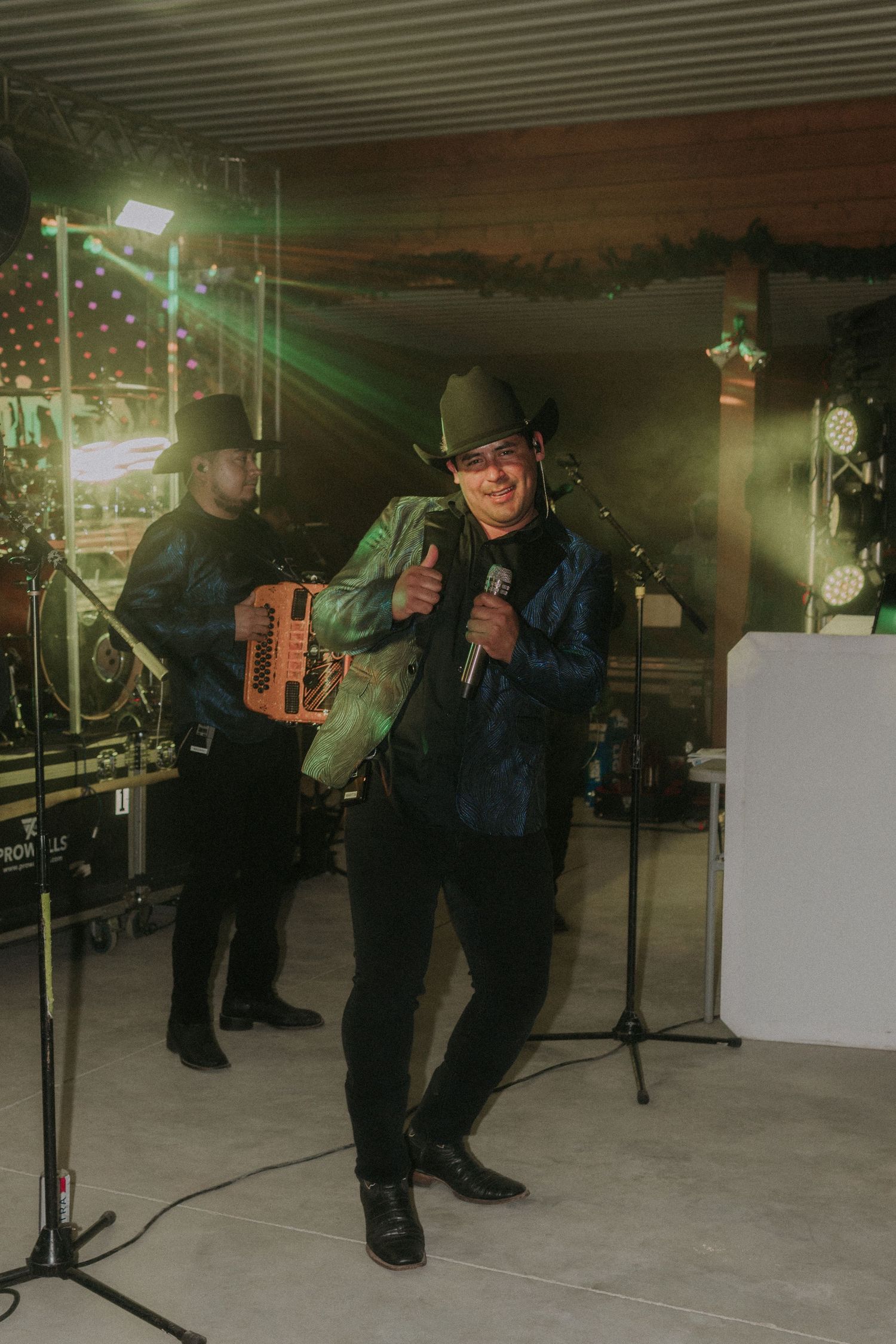 Musicians performing with accordions on a dimly lit stage.