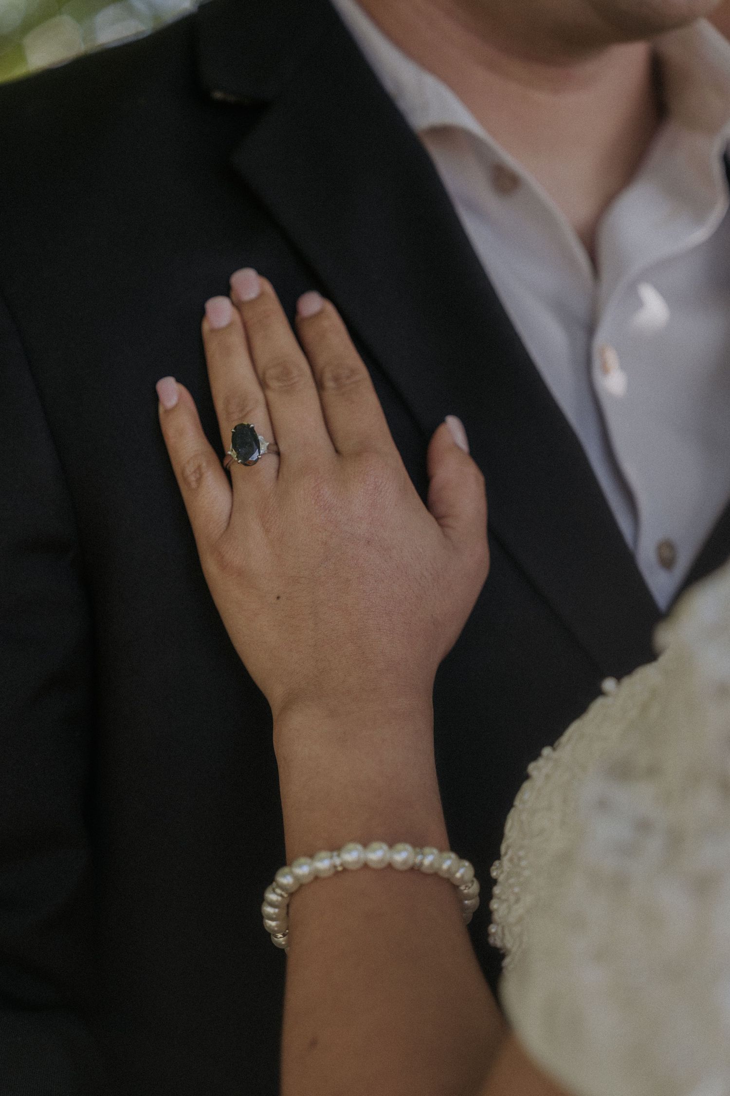 Close-up sequence showing hands with jewelry and rings in formal wedding attire.