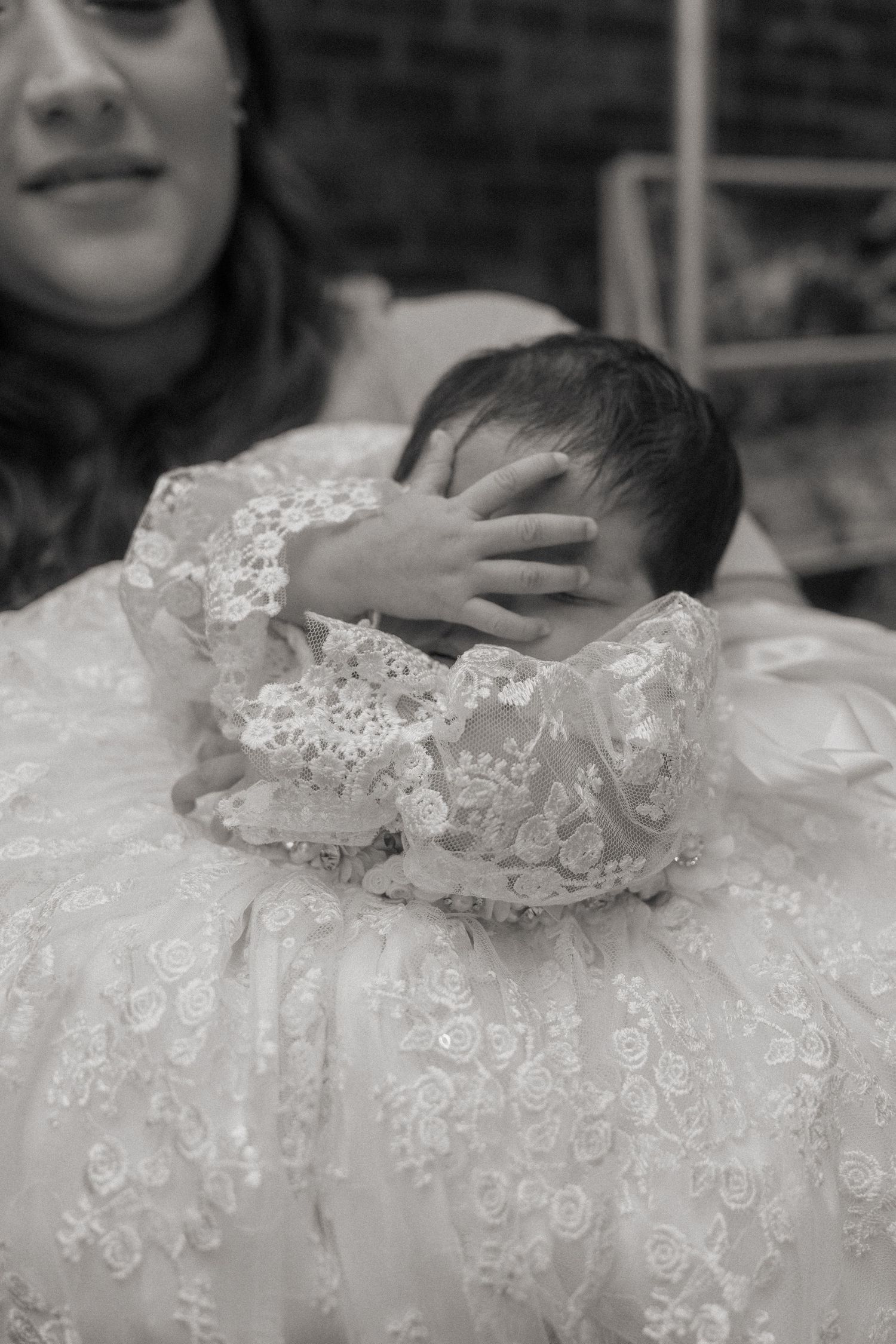 Close-up detail of white lace fabric with intricate floral embroidery pattern.