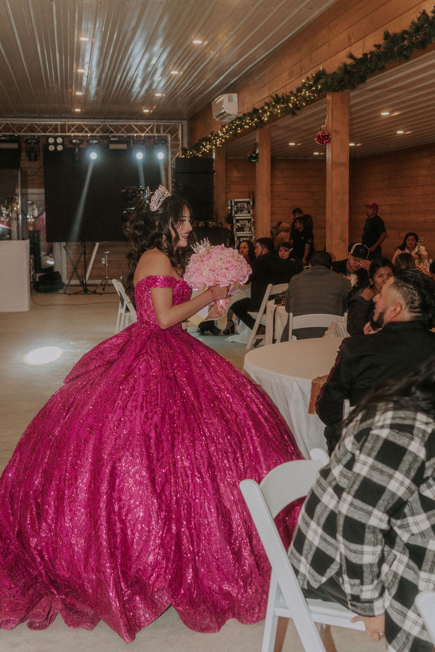 Event space with guests seated at tables and a striking magenta ballgown in view.