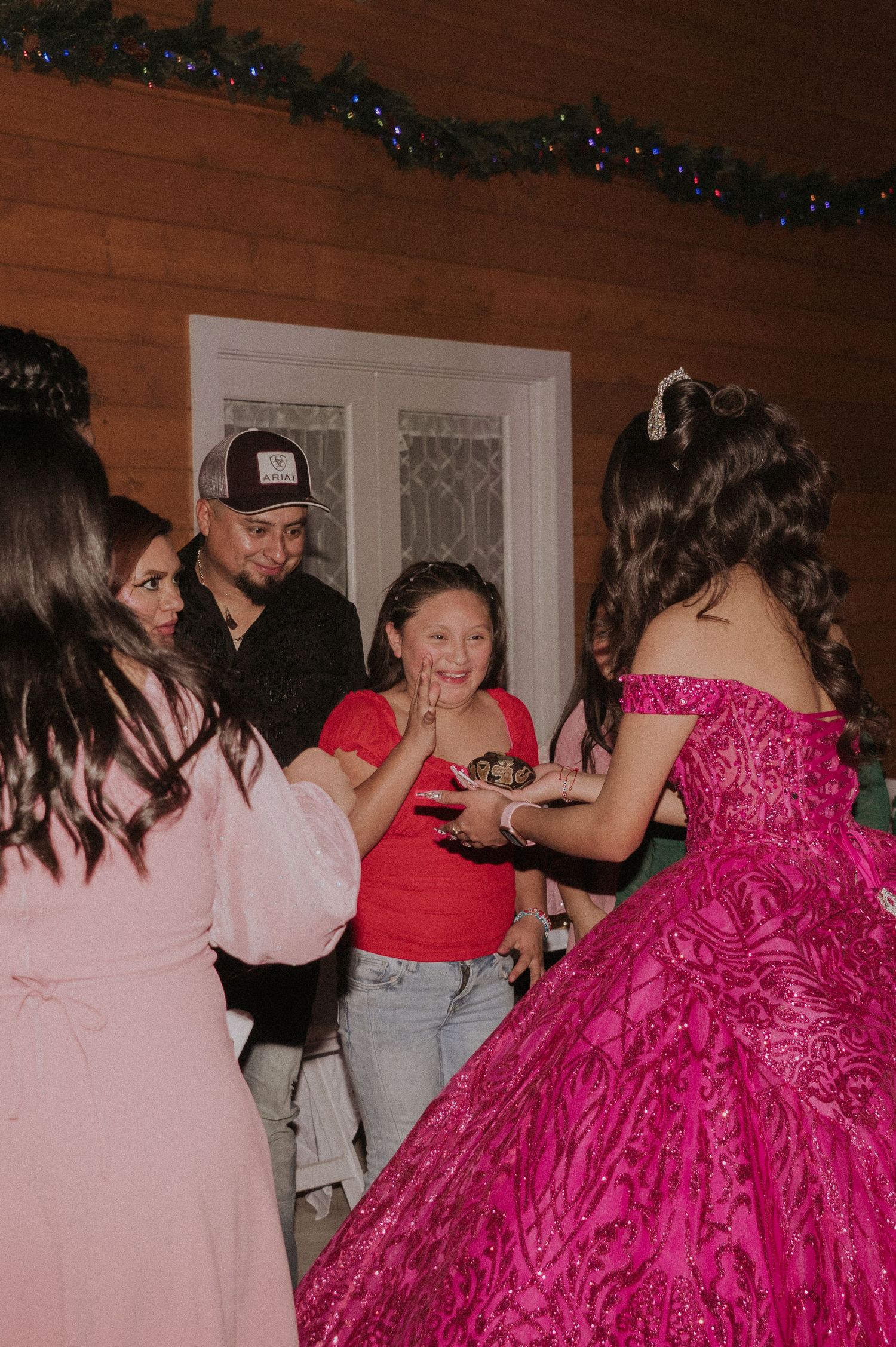 People dancing and celebrating at a Sweet 16 party featuring a stunning hot pink ball gown.