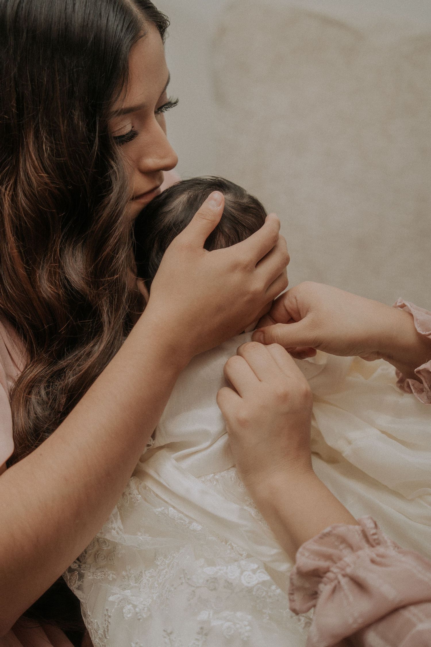 Hands gently hold and examine delicate white lace fabric details.