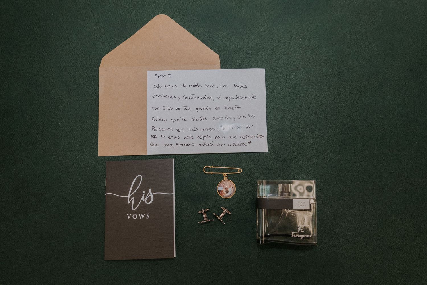Flat lay of groom's wedding details including his vows booklet, handwritten letter, envelope, cufflinks, and a small keepsake box.