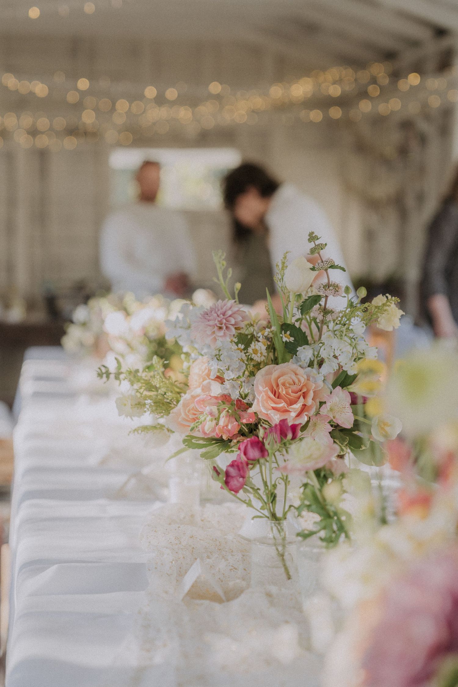 Elegant wedding reception tables with colorful floral centerpieces.