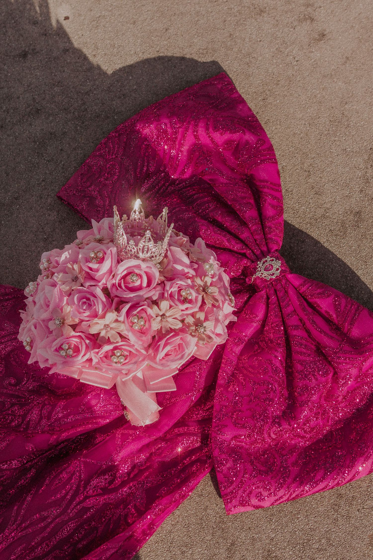 Close-up of pink roses against a magenta lace fabric with intricate details.