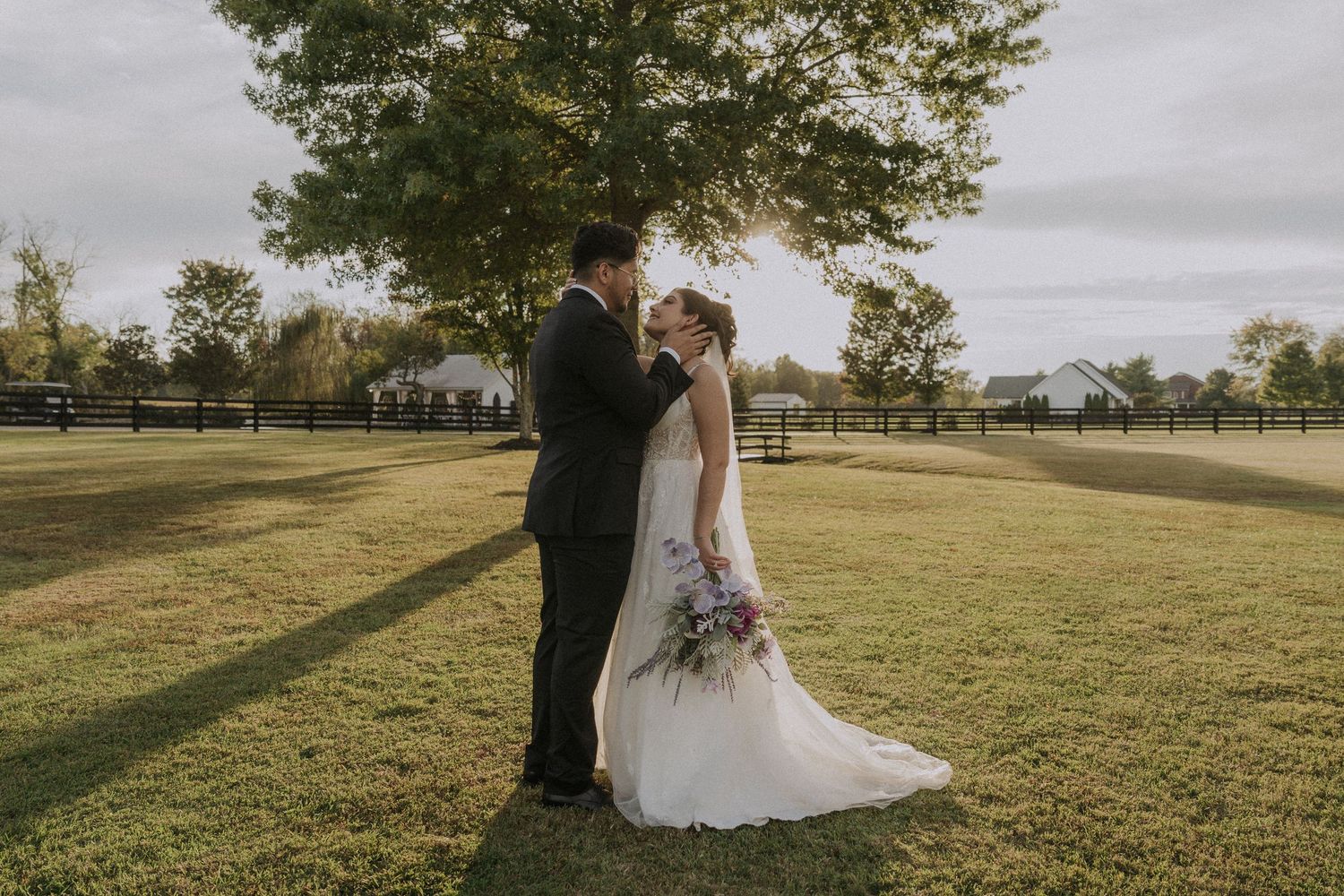 Wedding couple portraits in a sunlit outdoor field with natural landscape.