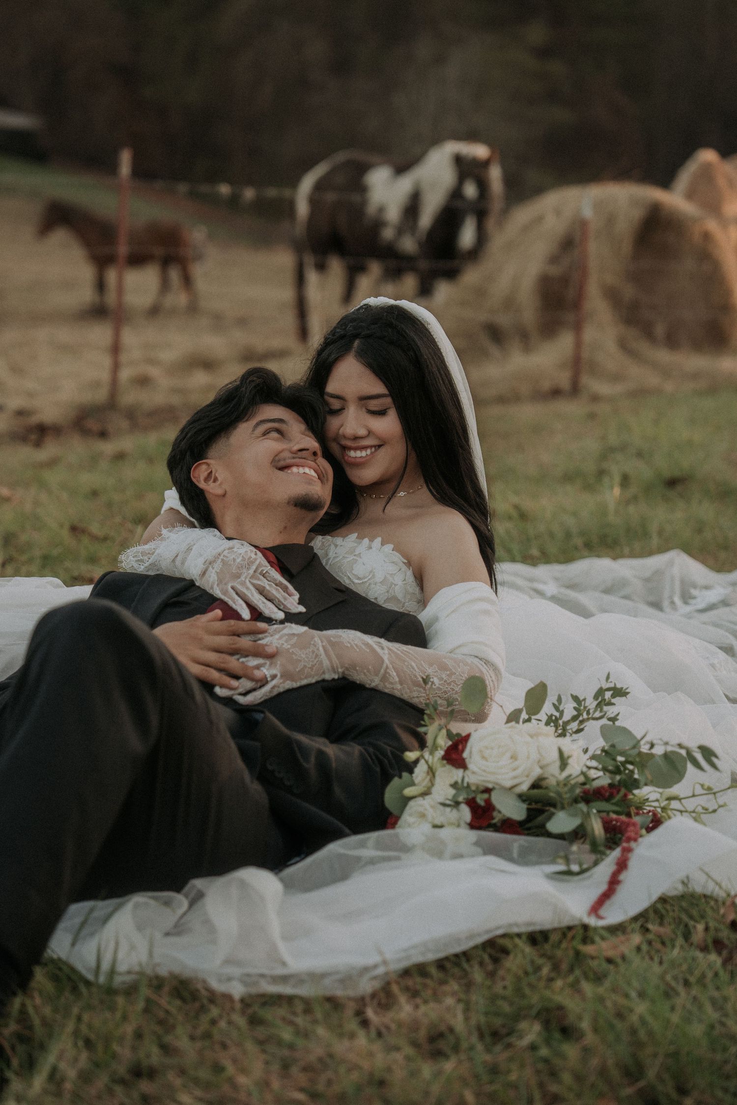 Newlyweds laying in grass sharing romantic moments during outdoor photo session.