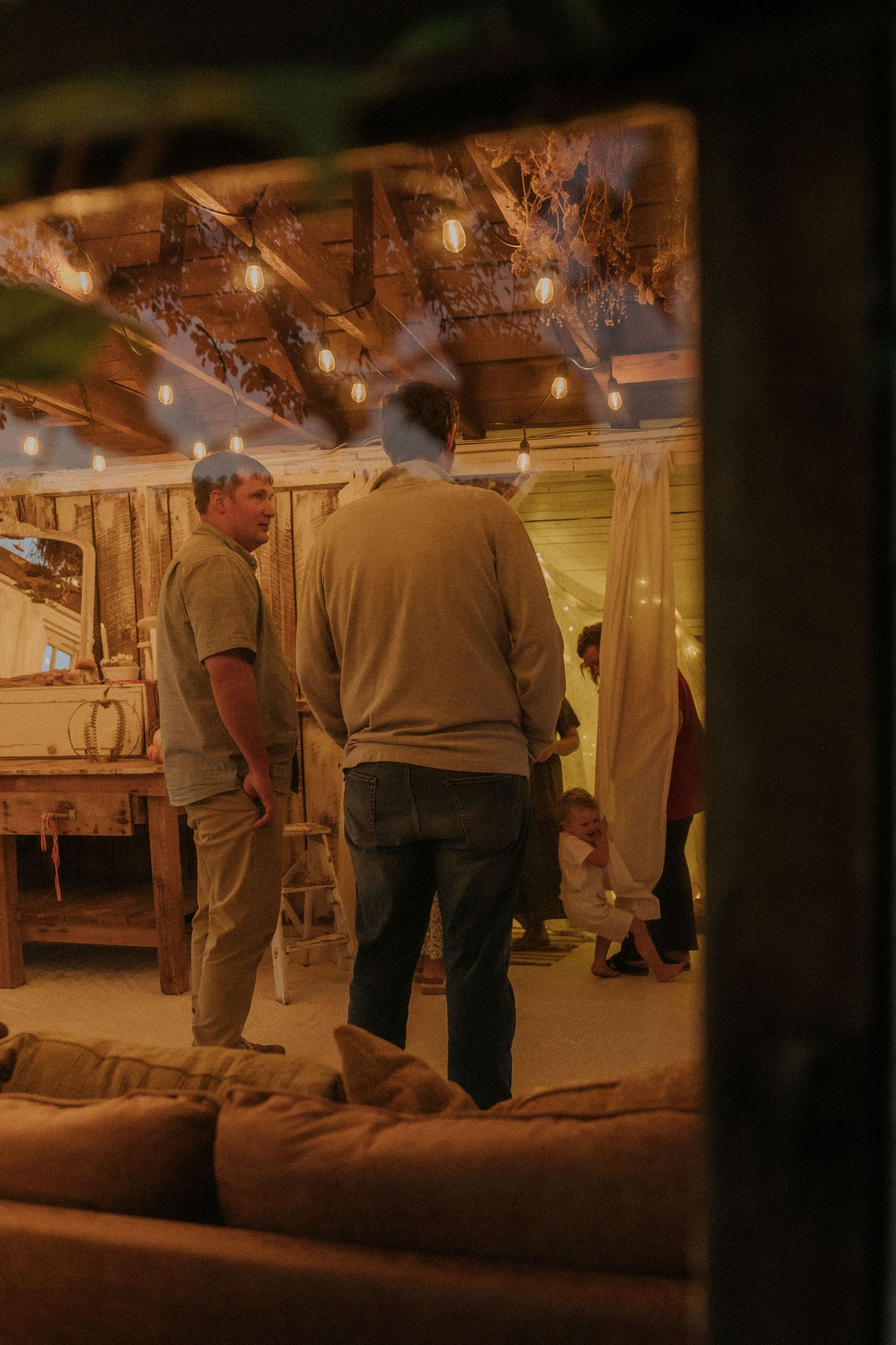 People gathered in a rustic indoor space with warm ambient lighting.