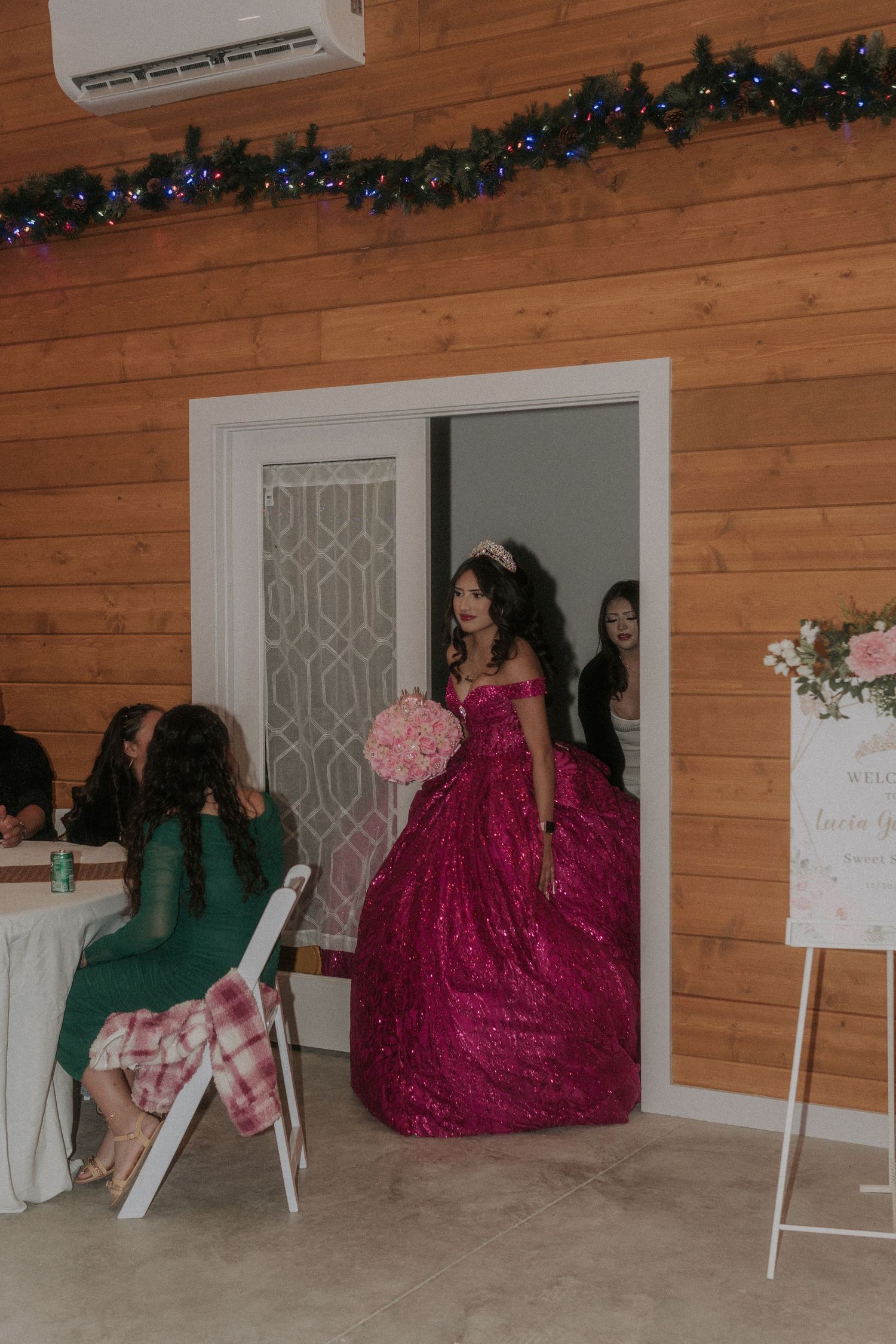 Wooden-walled venue space decorated for a Sweet 16 with a magenta ballgown visible.