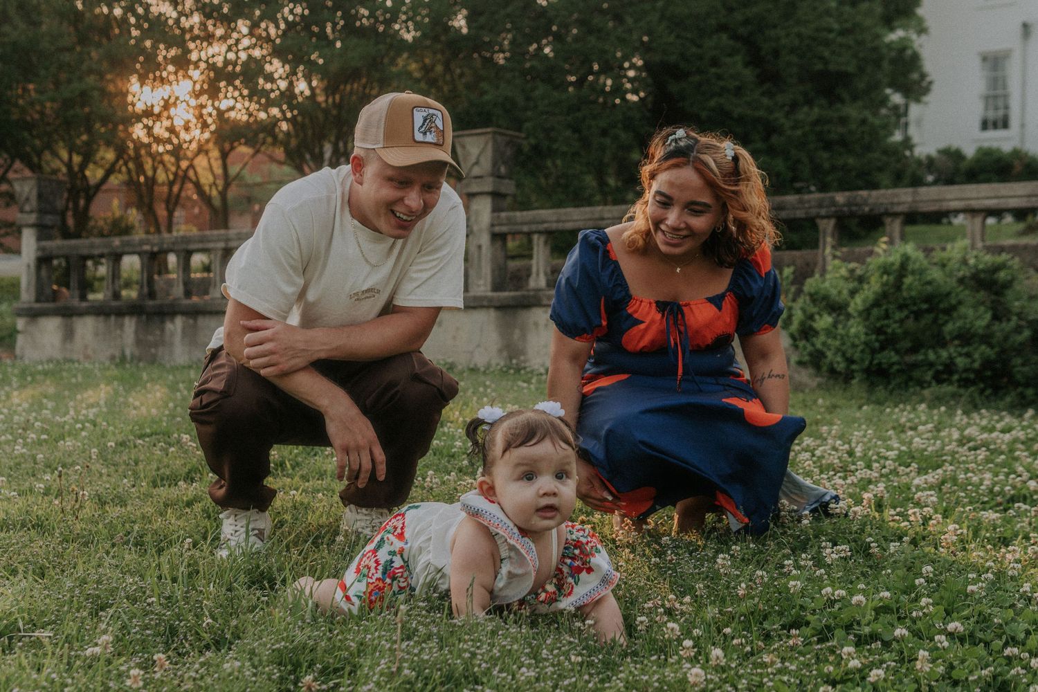 Candid moments of family lounging in flowering meadow on spring evening.