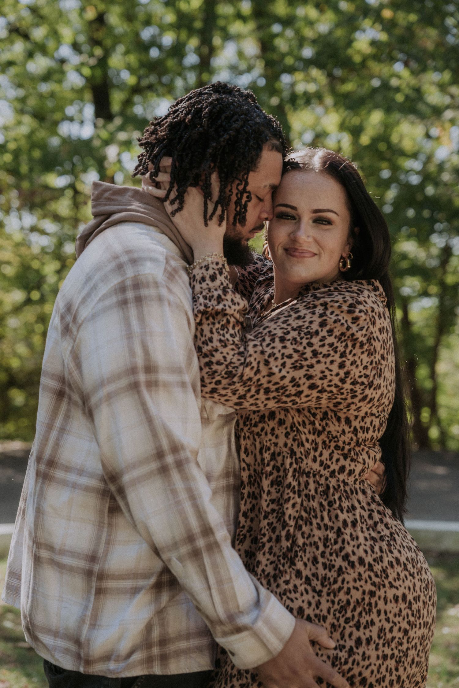 A couple embraces outdoors wearing plaid and leopard print clothing.