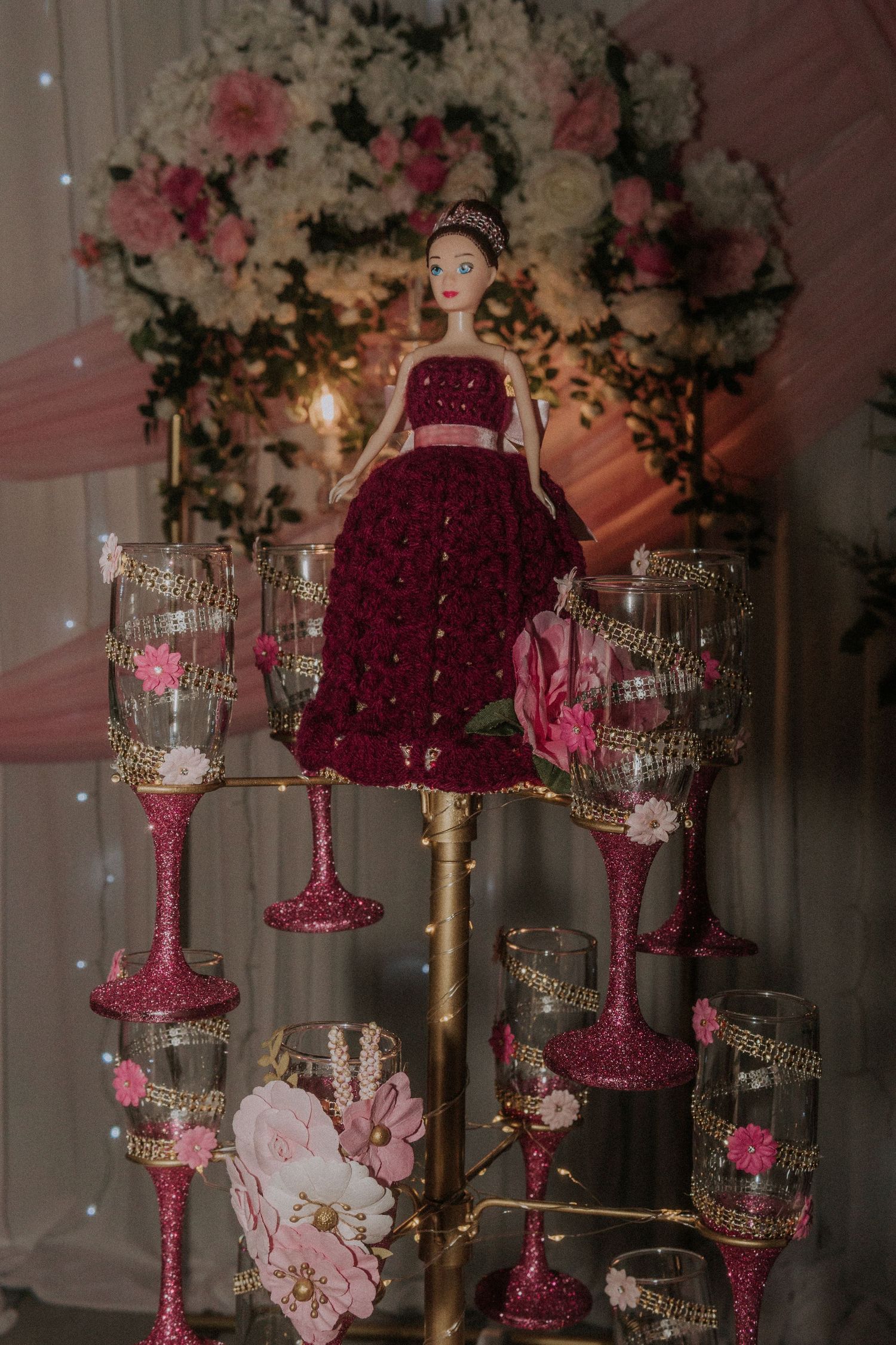 Elegant reception table with crystal glasses and pink floral centerpieces.