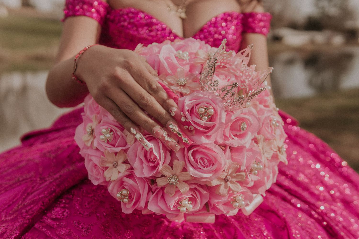Pink and white rose bouquet held against a magenta quinceañera dress.