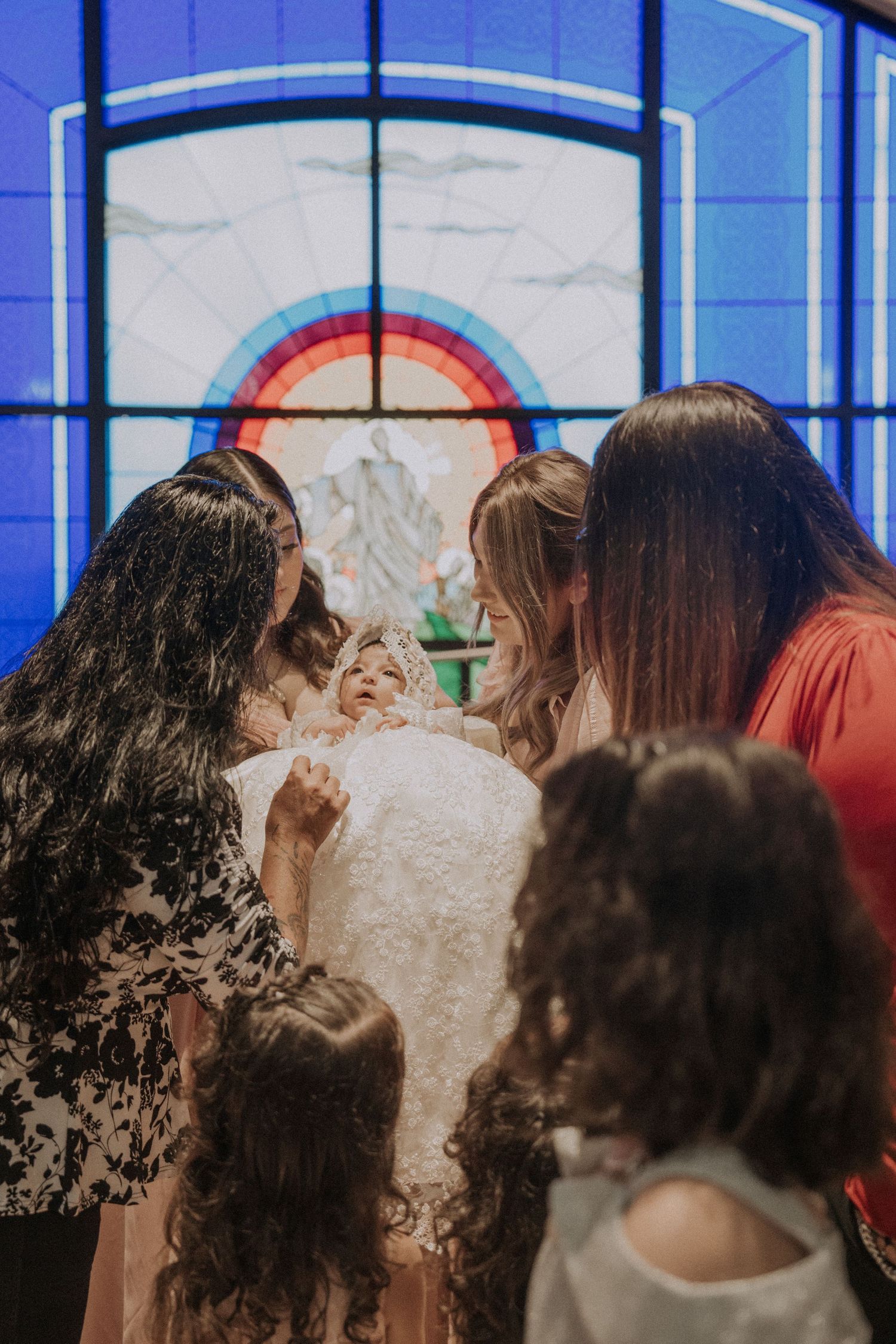 Church interior with blue stained glass windows during a ceremony.