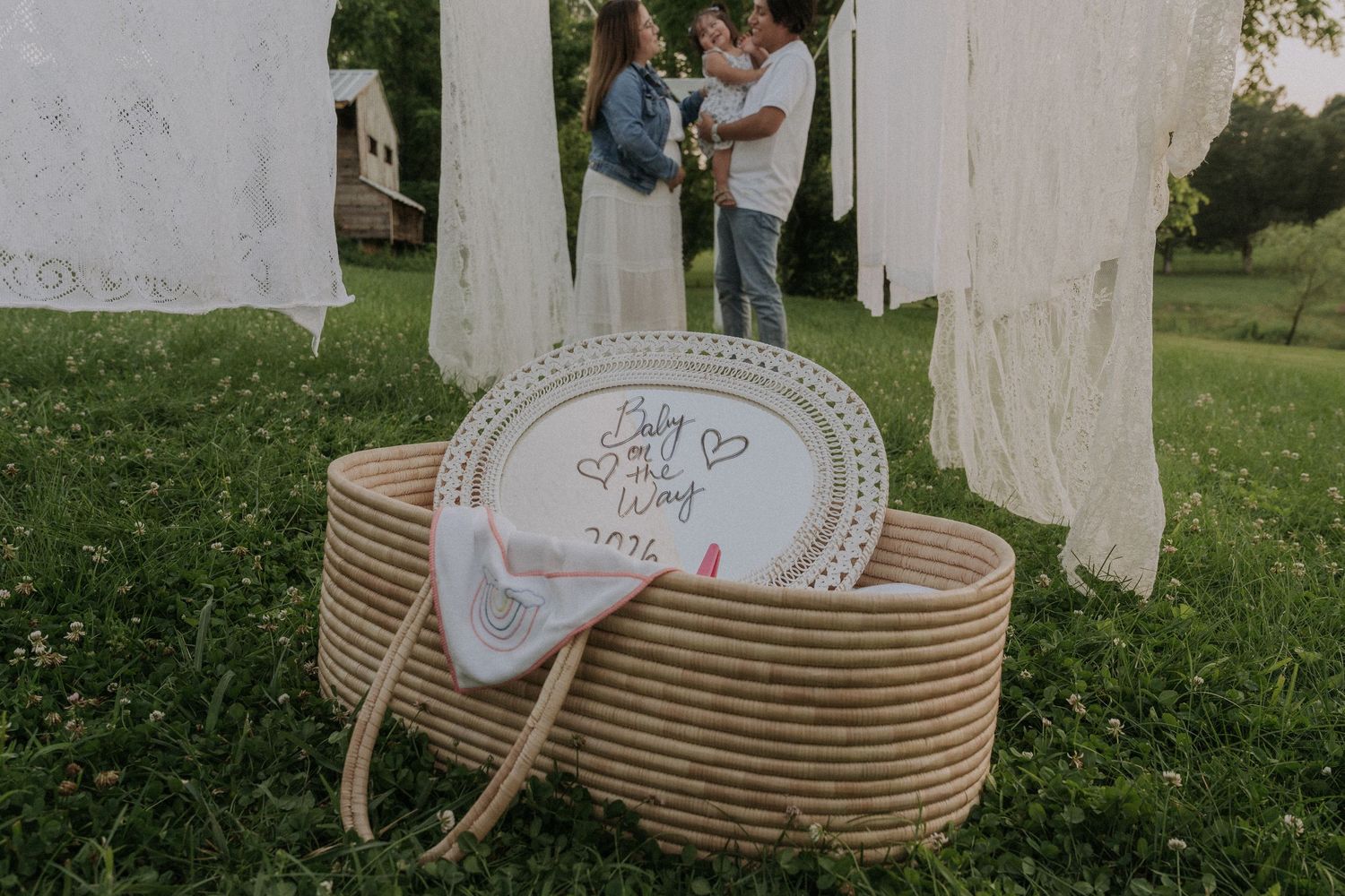 Rustic decorative items and textiles arranged in an outdoor setting for a gender announcement.