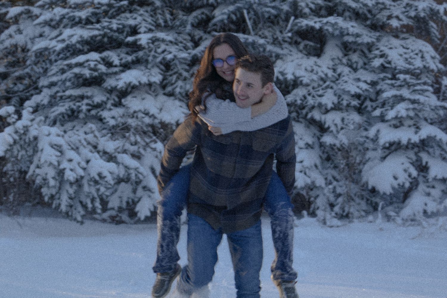 Two people having fun playing and frolicking in a snowy winter wonderland landscape.