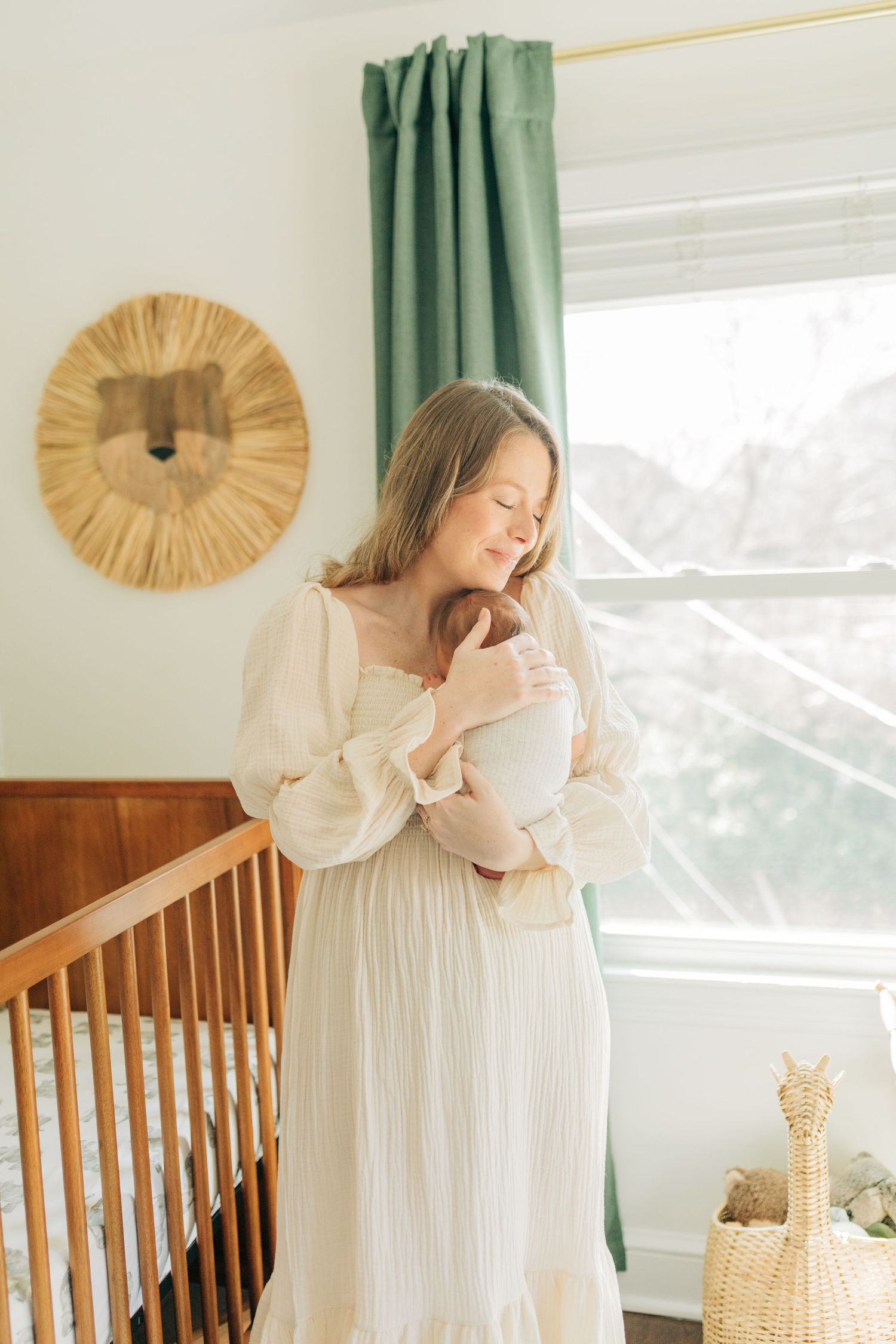 Serene nursery scene with white dress, wooden crib and decorative lion wall art.