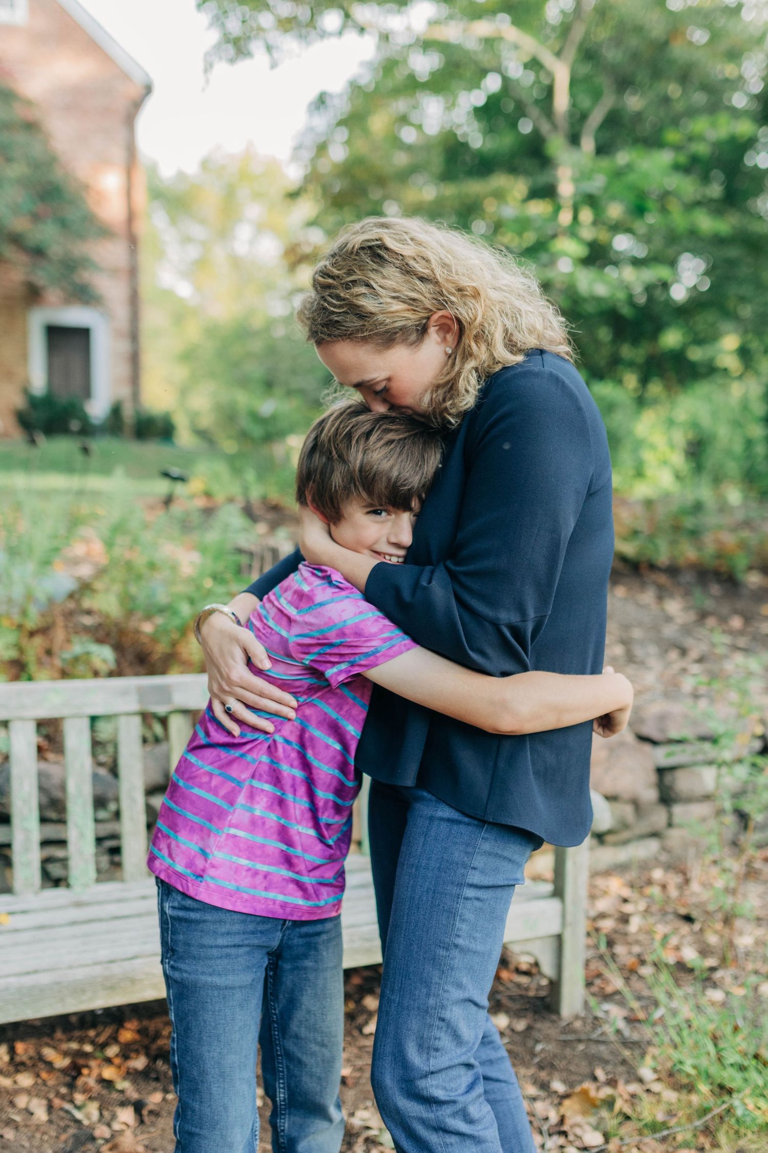 Heartwarming embrace captured in an outdoor setting with green foliage.