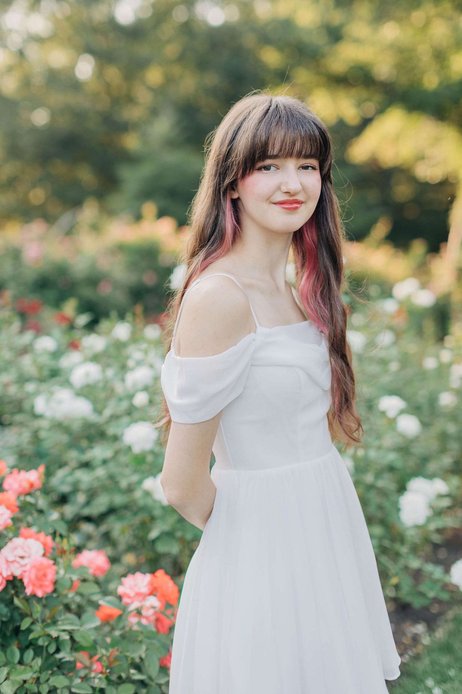 Garden portrait with someone in white dress surrounded by summer blooms.