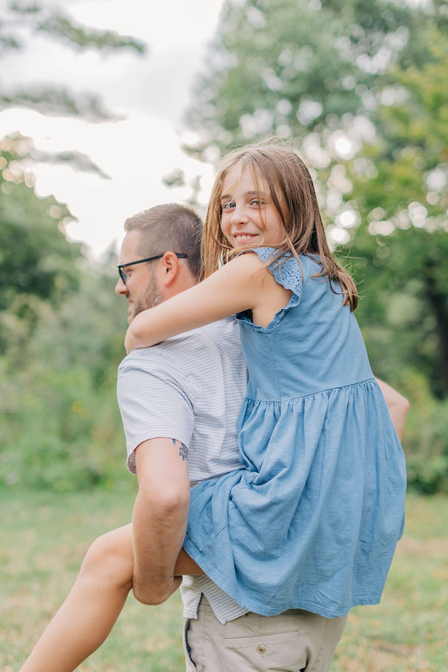 Playful piggyback rides in a sunny outdoor setting surrounded by greenery.