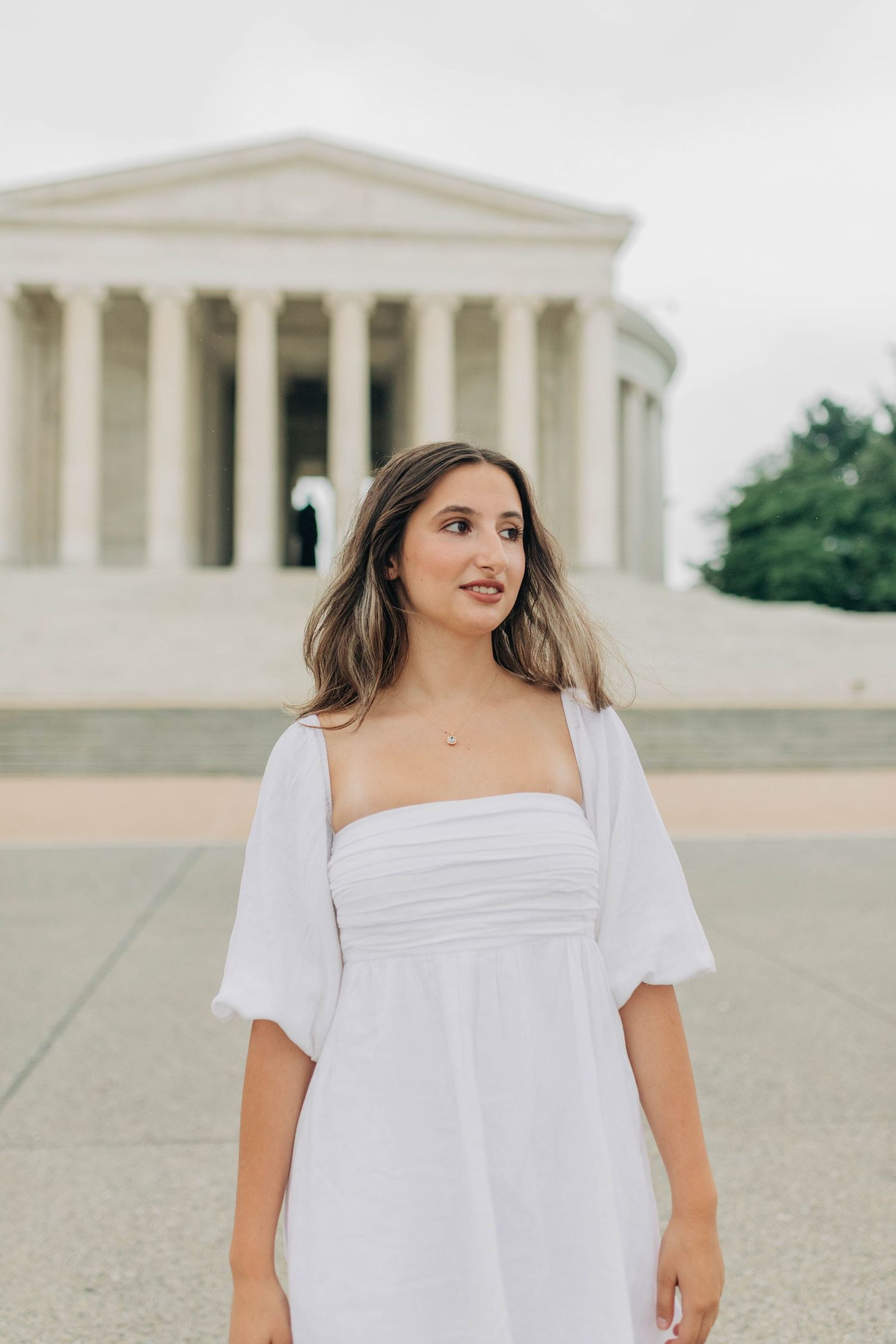 Elegant white dress portrait in front of the Supreme Court building in Washington DC.
