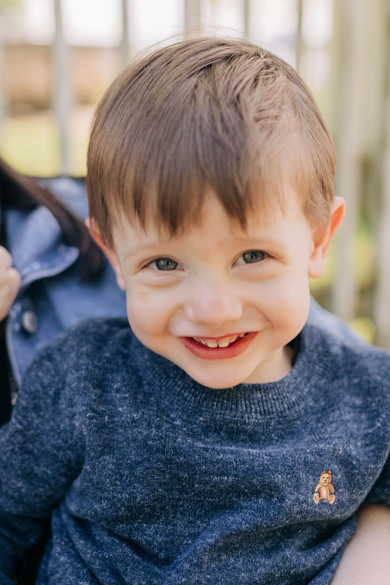 Close-up series of a young child wearing a navy blue sweater with different expressions.