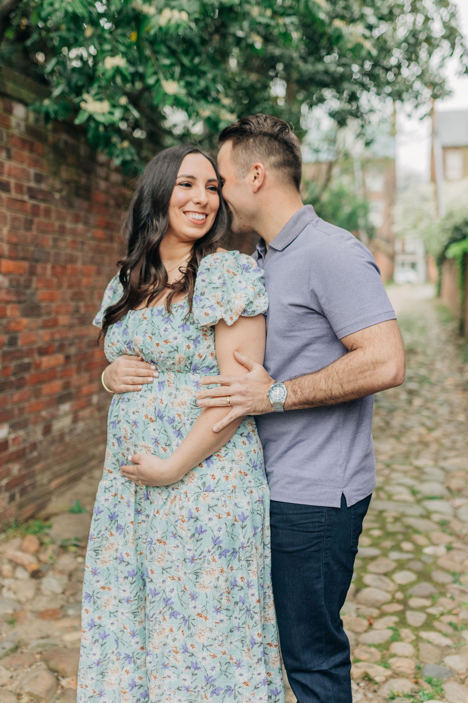 A couple enjoys a tender moment together on a scenic cobblestone path.